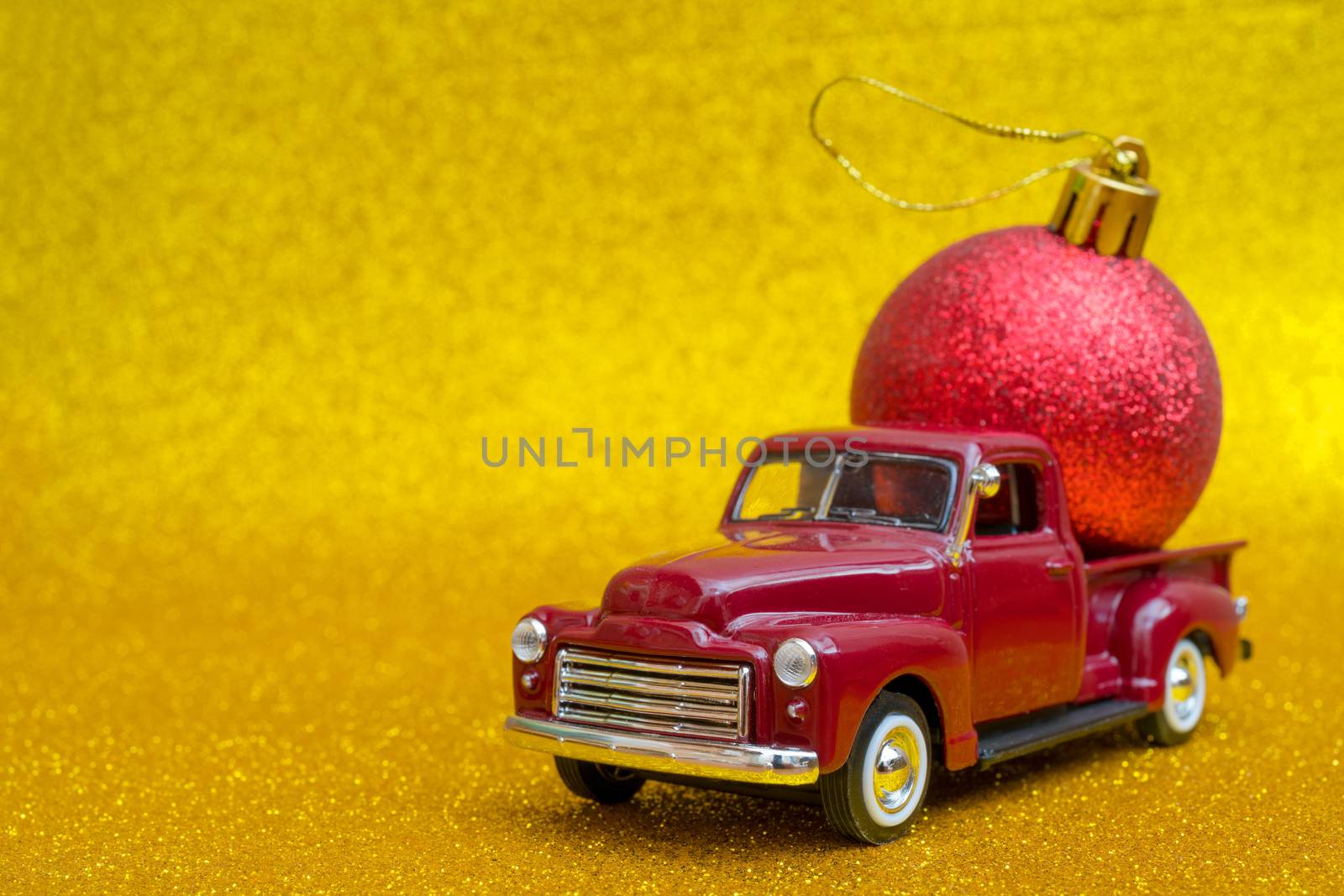 Toy car carries Christmas toy ball for holiday.