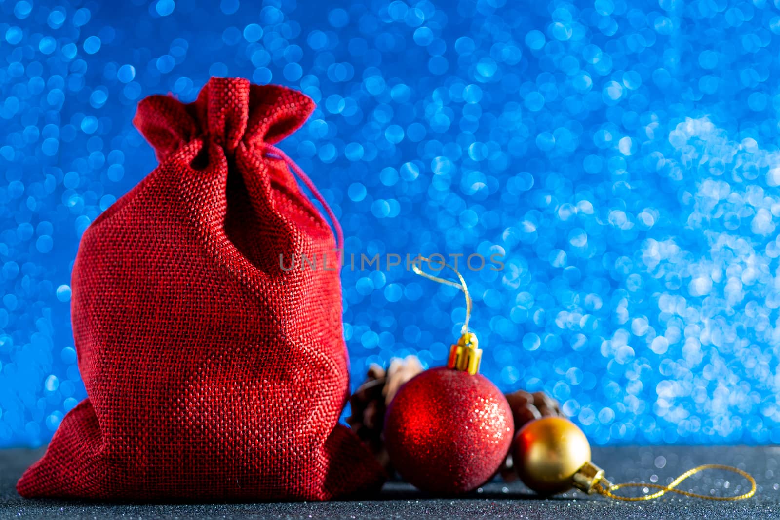 Christmas blue background. Red gift bag and Christmas toys.