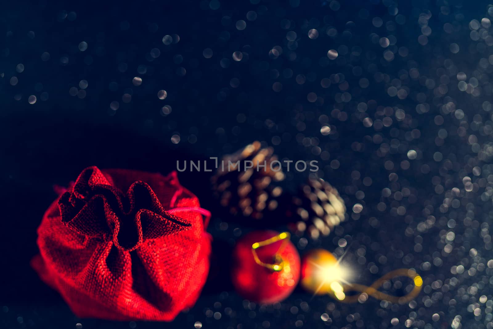 Christmas shiny black background. Red gift bag and Christmas toys.