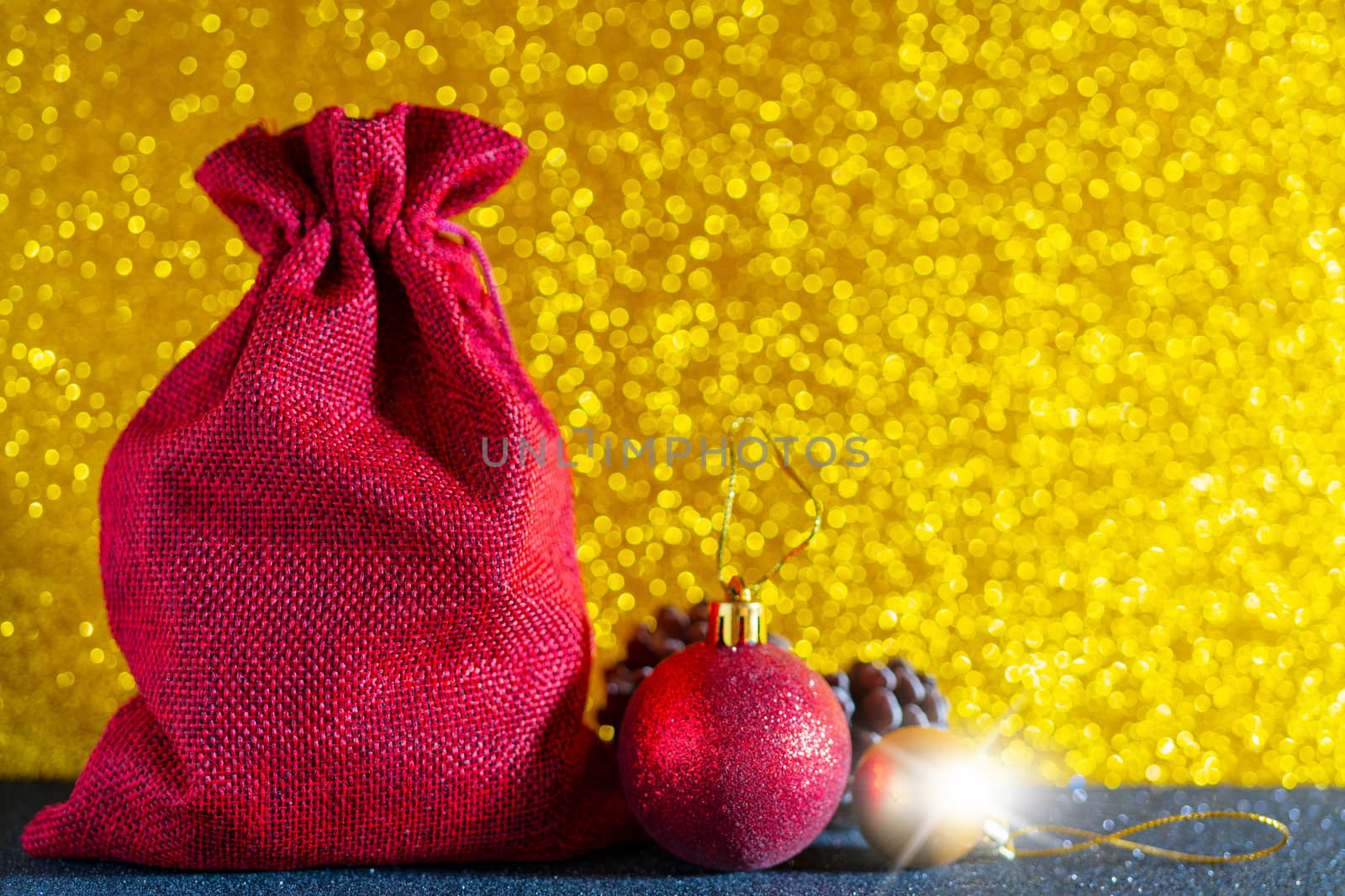 Christmas golden background. Red gift bag and Christmas toys.