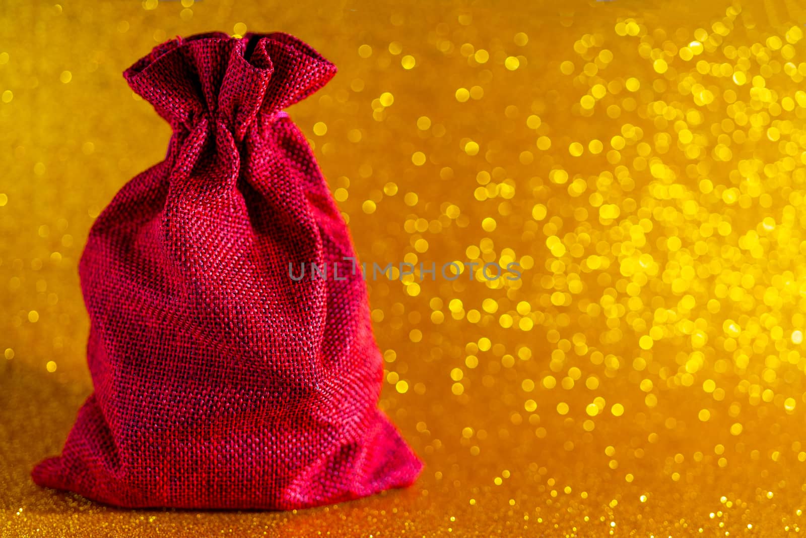 Christmas golden background. Red gift bag and Christmas toys.