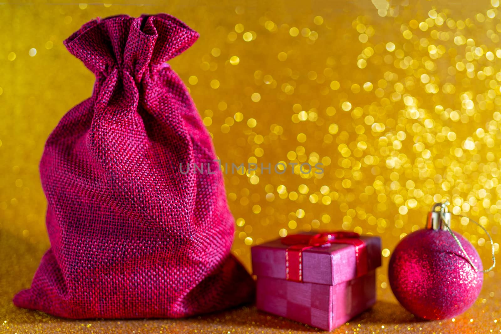 Christmas golden background. Red gift bag and Christmas toys.