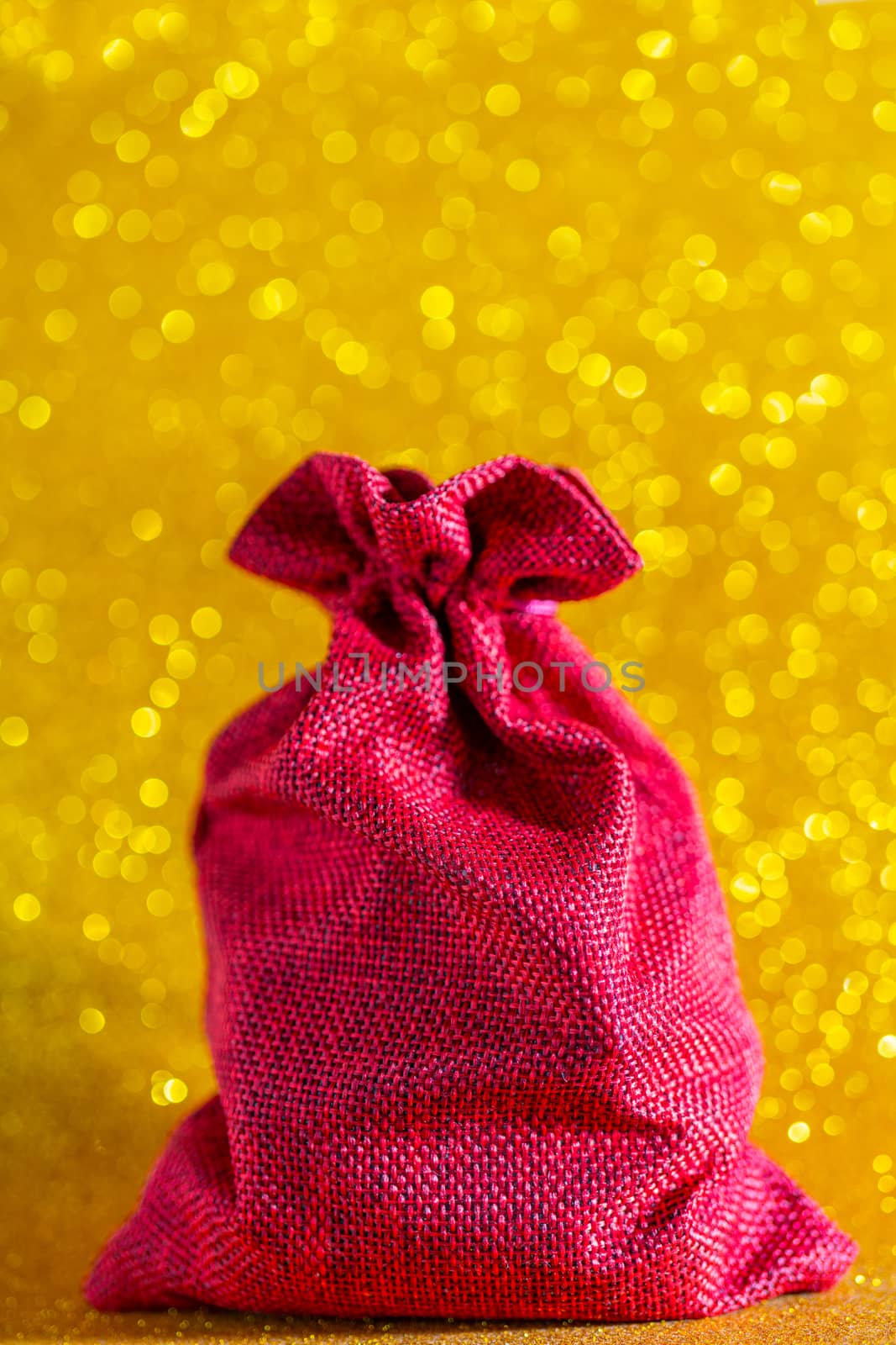 Christmas golden background. Red gift bag. Beautiful bokeh.