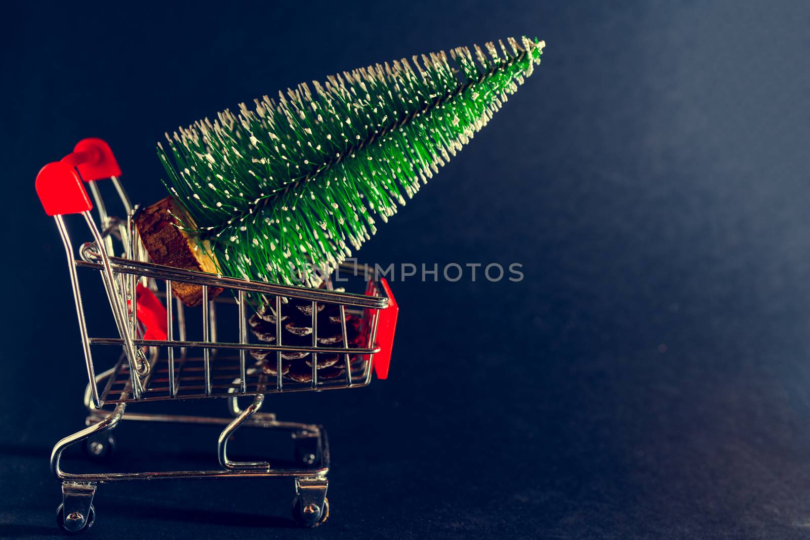 Christmas black background. Supermarket trolley and Christmas tree.
