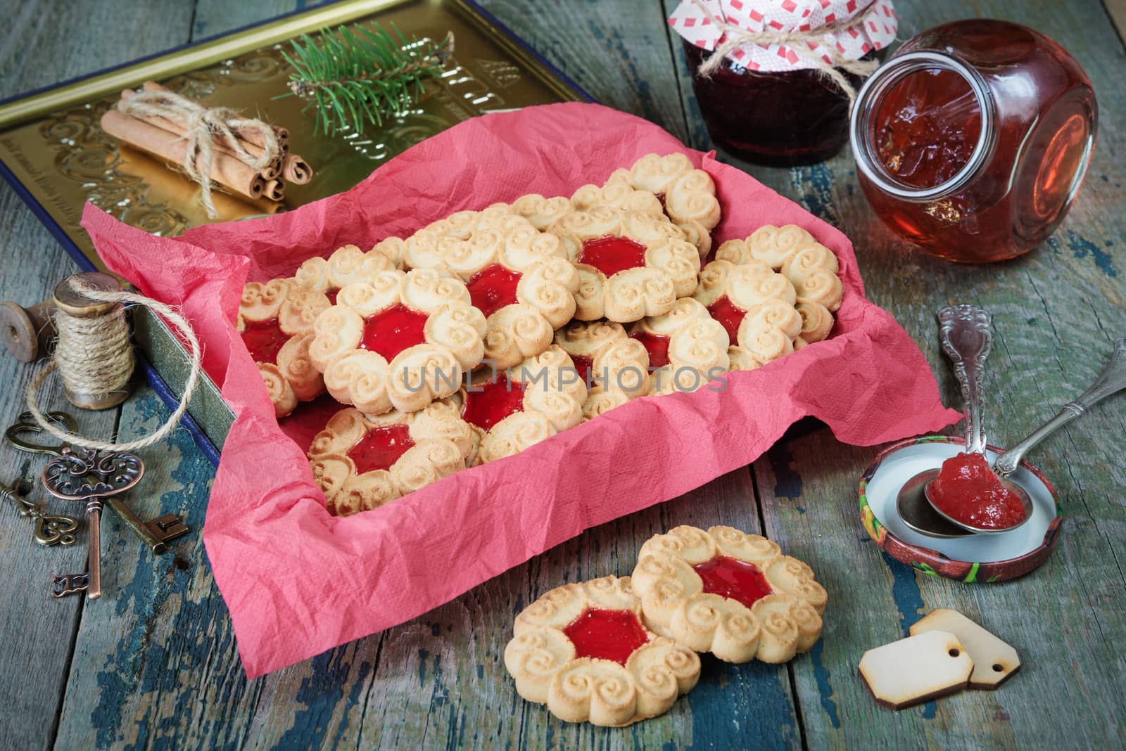 Sweet Christmas cookies with jam and fir branche on the old wooden table