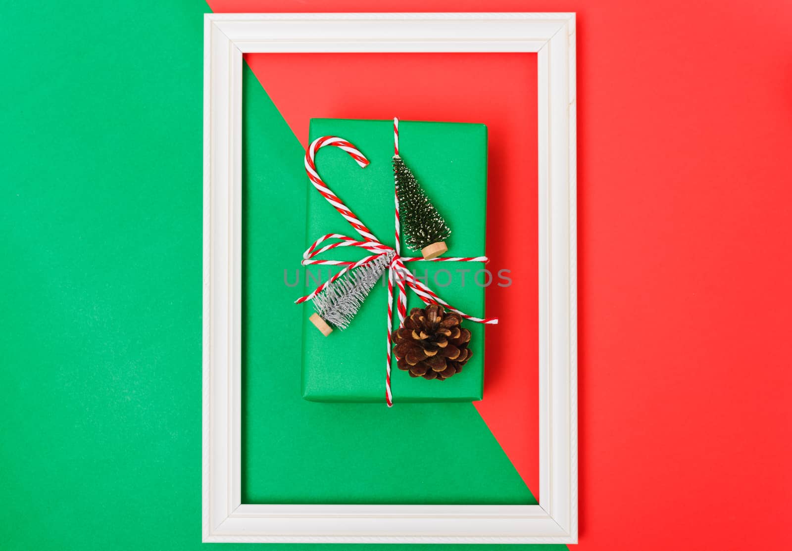 New Year, Christmas Xmas holiday composition, Top view gift green box, clews of rope, green fir tree branch on red and green background with copy space