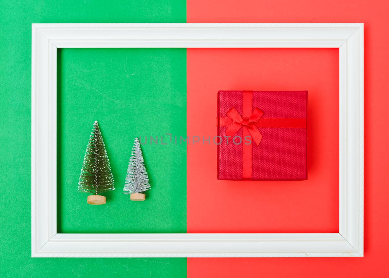 New Year, Christmas Xmas holiday composition, Top view green fir tree branch and red gift box in frame on red and green background with copy space