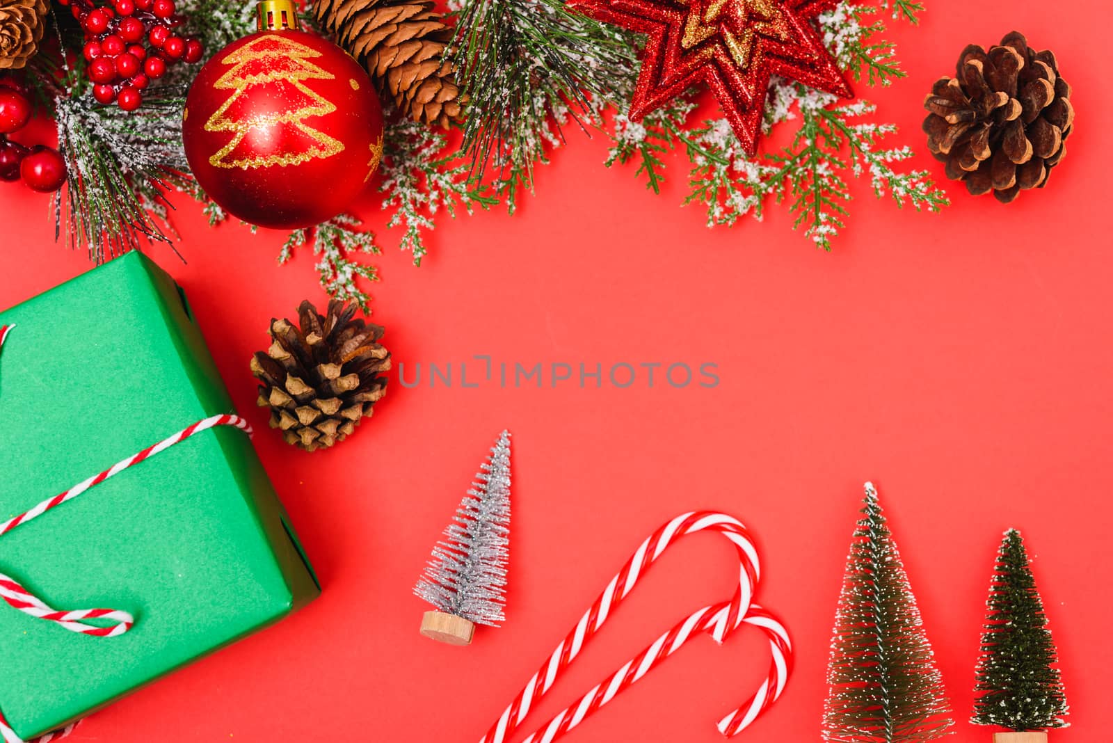 Christmas green gift box and decorations, fir tree branches on red background. Merry Christmas concept. With Copy space for text