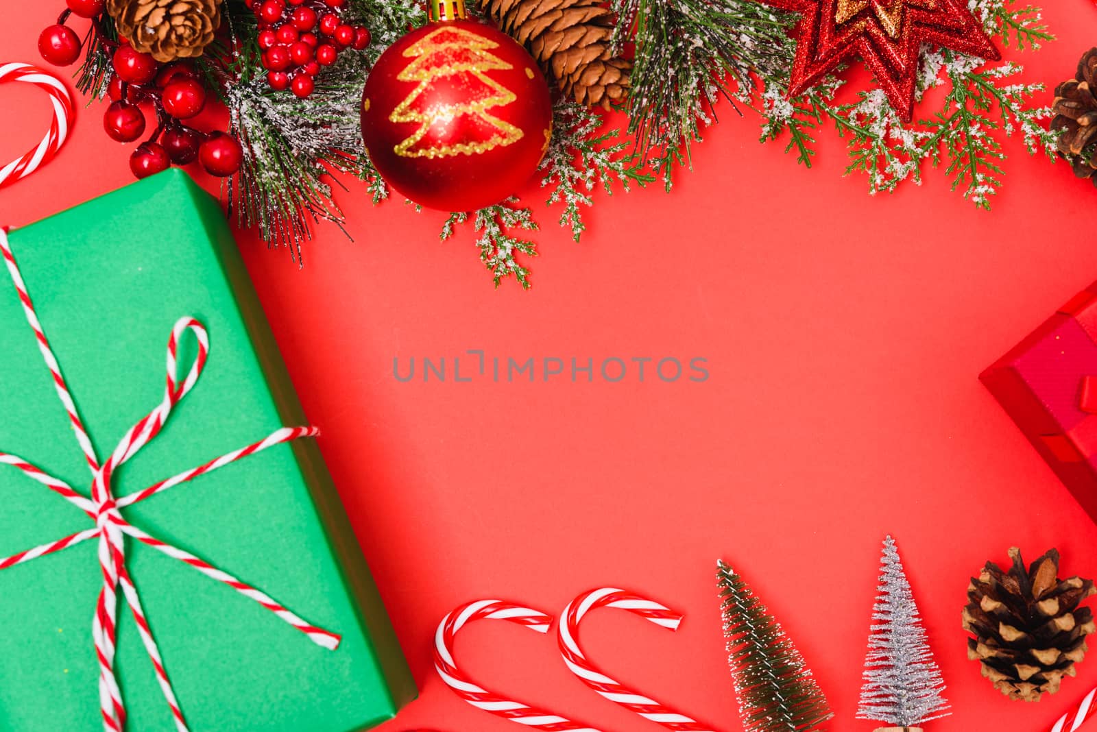 Christmas green gift box and decorations, fir tree branches on red background. Merry Christmas concept. With Copy space for text