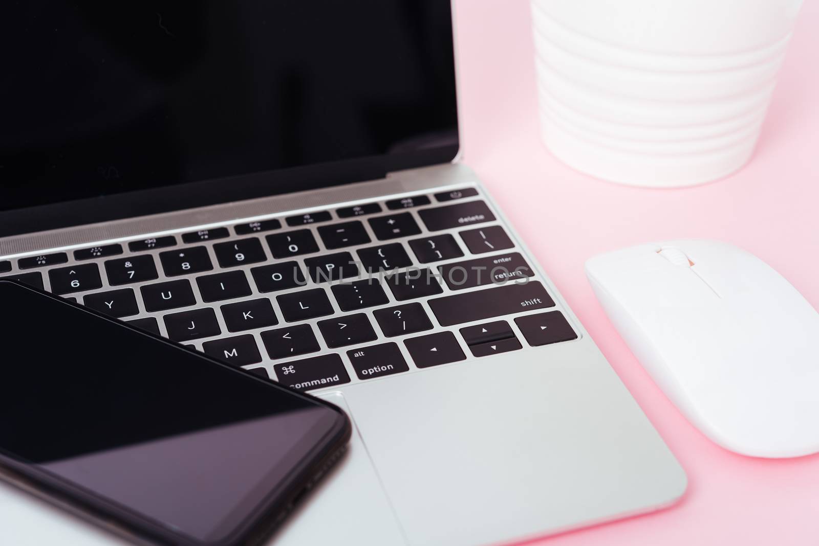 Top view of modern technology smart phone mobile and computer laptop on pink background with copy space