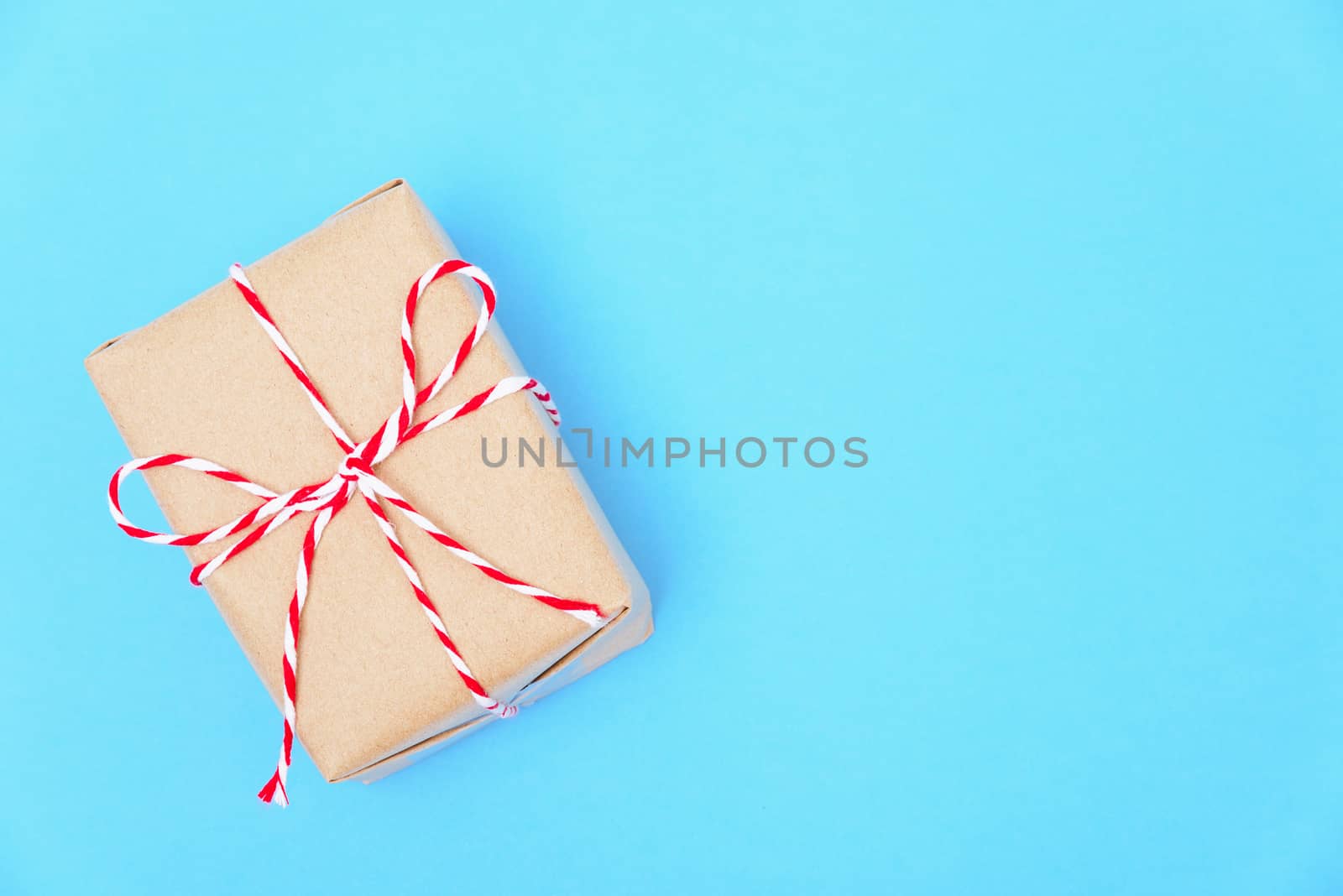 Happy New Year and Christmas 2020 or valentine day, top view craft paper wrapped present Brown gift box craft on blue background with copy space for your text