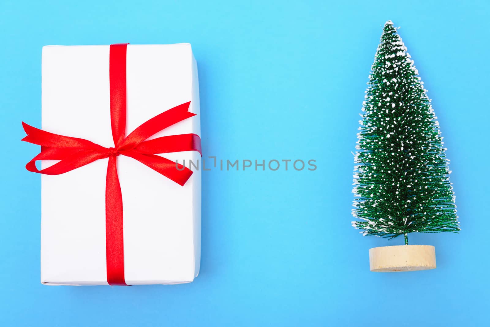 Happy New Year and Christmas 2020 or valentine day, top view craft paper wrapped present gift box craft and fir tree on blue background with copy space for your text