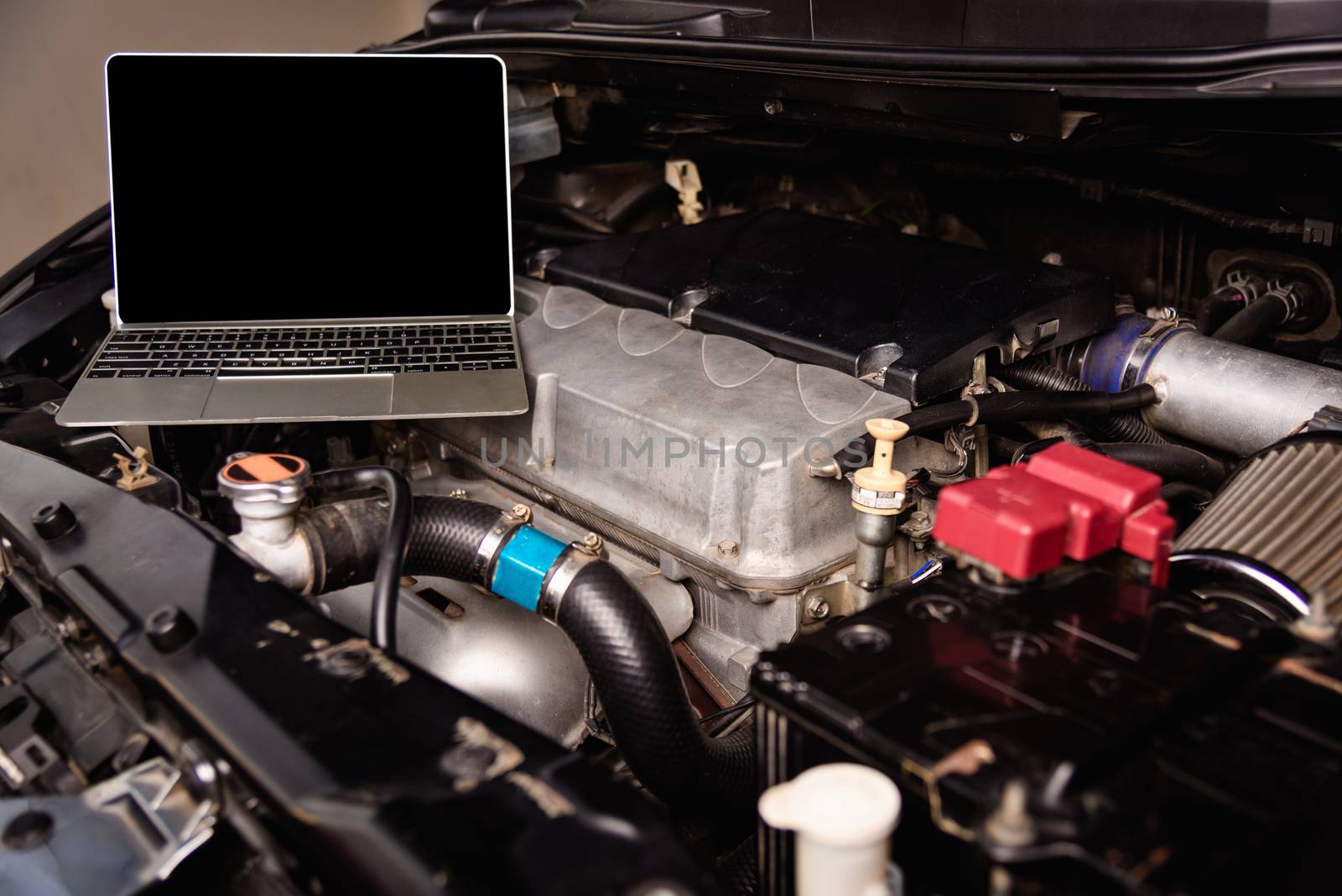 Laptop computer on car mechanic engine for service at workshop