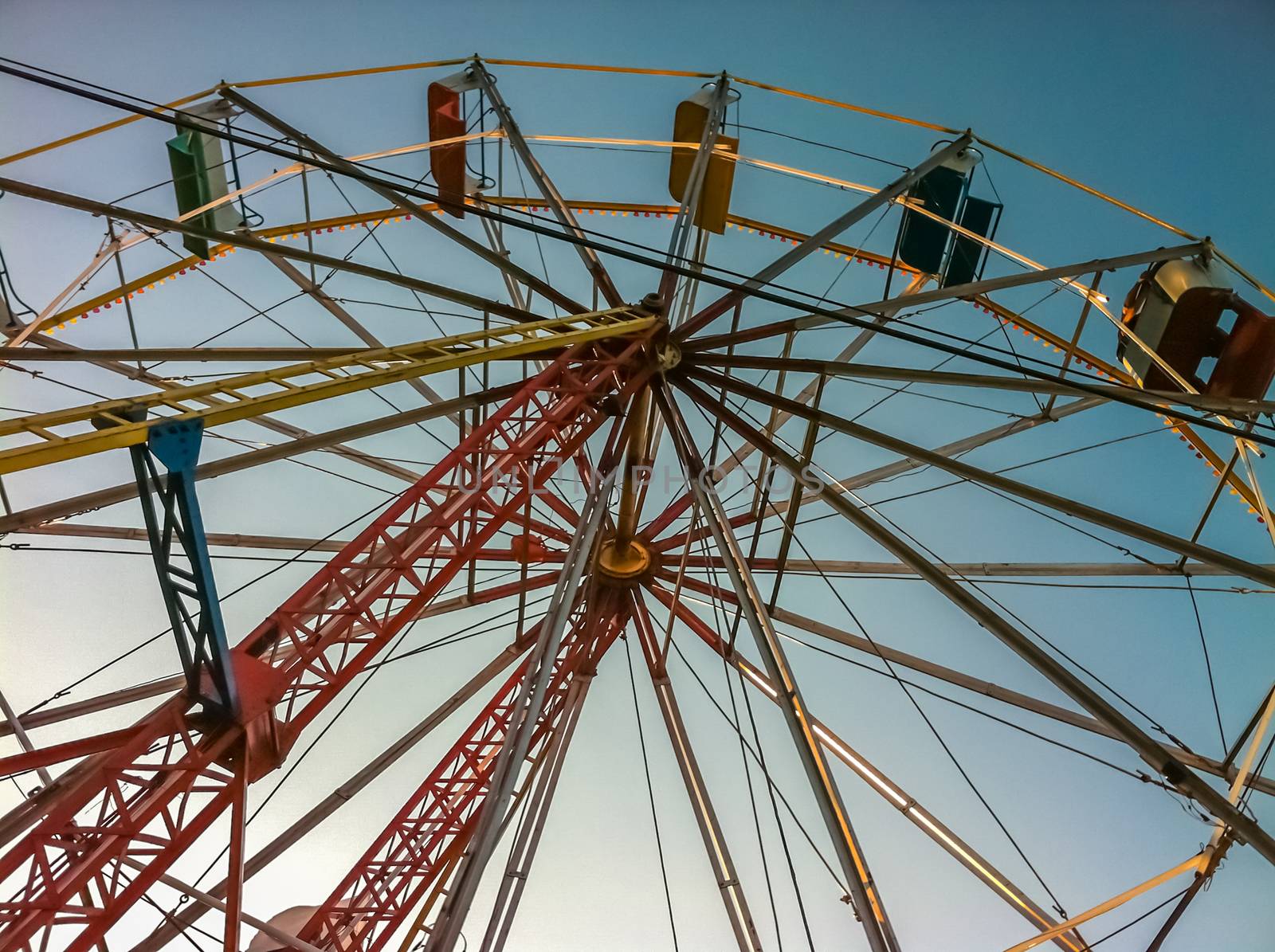 Multicolored ferris wheel over blue sky on a summer afternoon by leo_de_la_garza