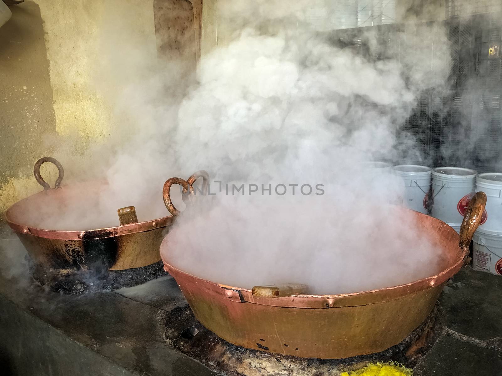 Two bronze casseroles on charcoals of boiling milk to make sweet caramel