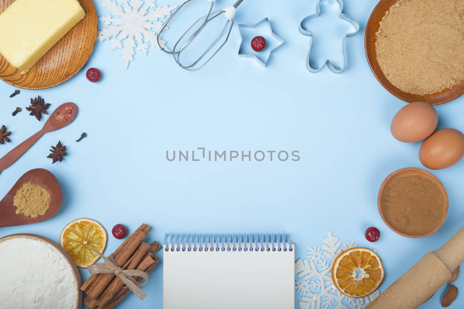 Christmas gingerbread cookies cooking background flat lay top view template with copy space for text. Baking utensils, spices and food ingredients on blue background