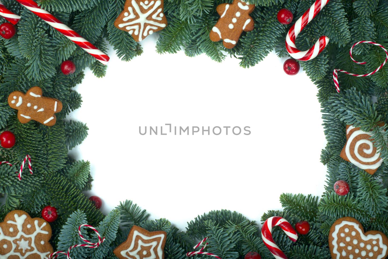Christmas design boder frame greeting card of noble fir tree branches and gingerbread cookies isolated on white background