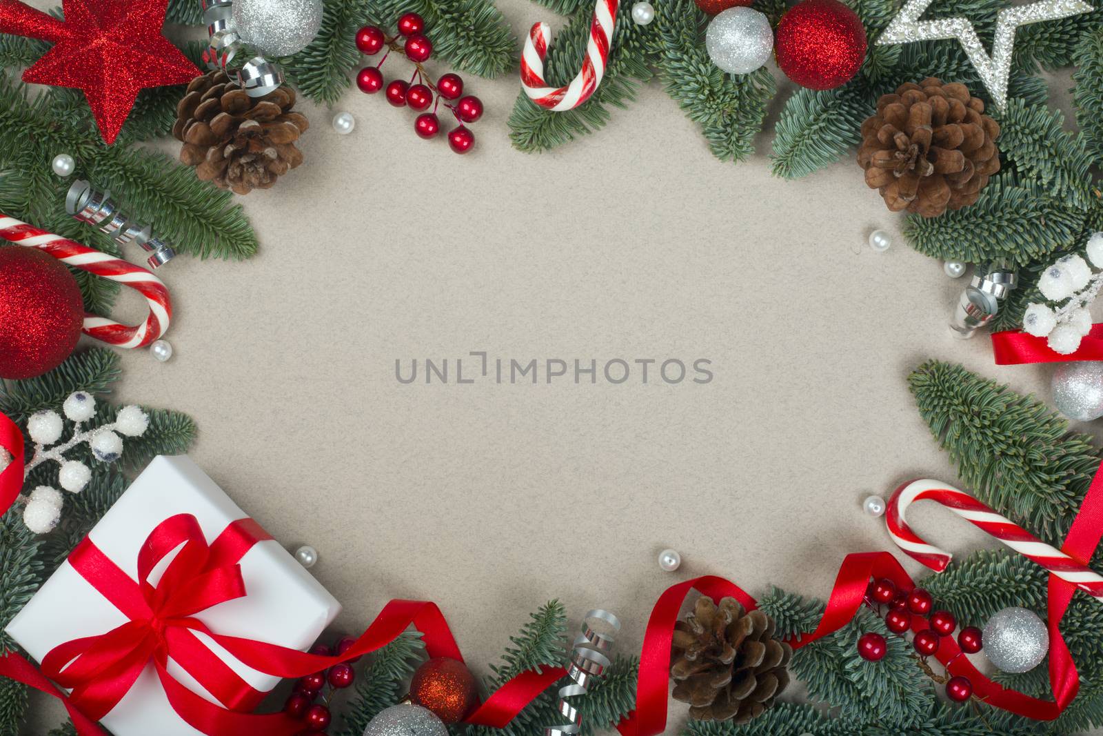 Christmas noble fir tree twigs gift and decorations on brown paper background with copy space for text