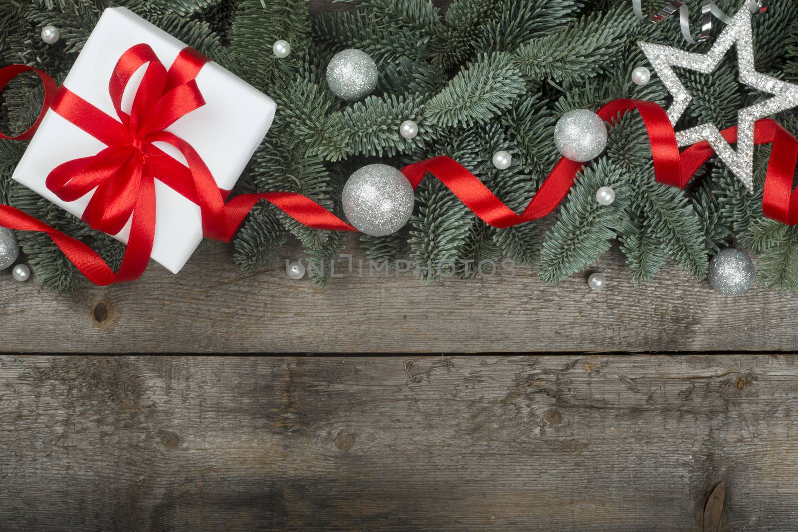 Christmas gift fir tree branches with festive decoration on wooden background