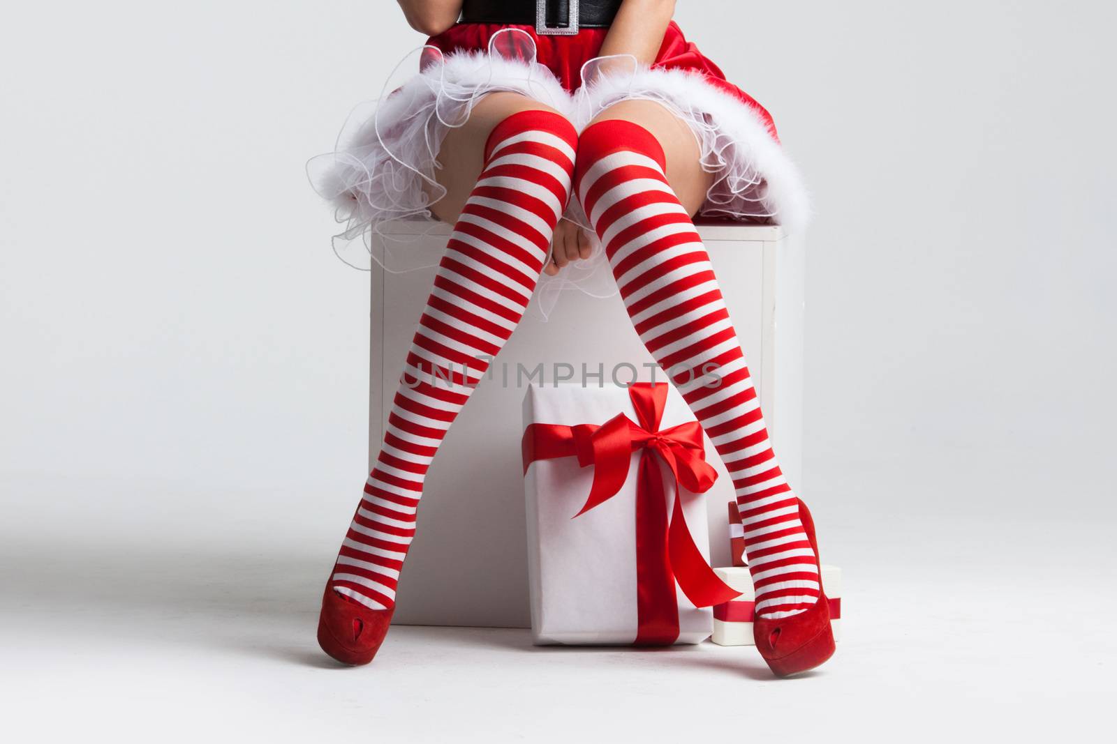 Santa woman legs in striped stockings and christmas gift, Christmas shopping concept
