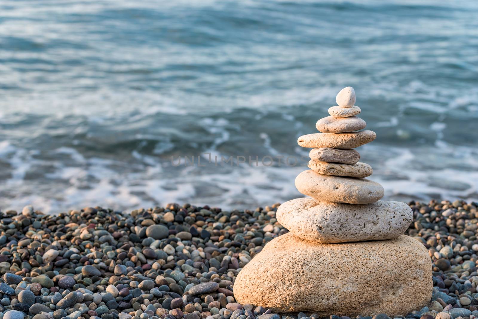 Pyramid of white stones on a pebble beach close-up concept photo by kosmsos111