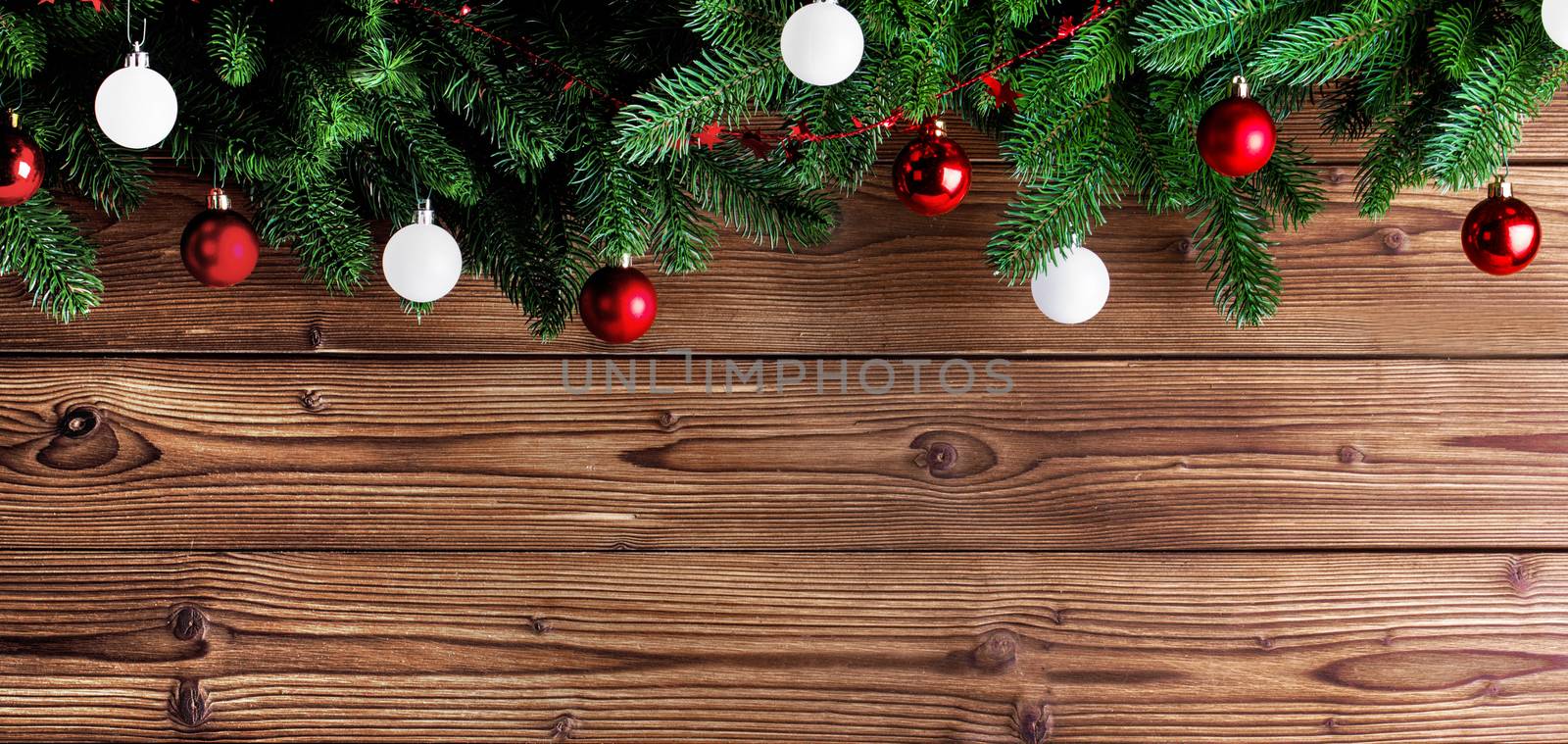 Christmas fir tree and decorative baubles on wooden background