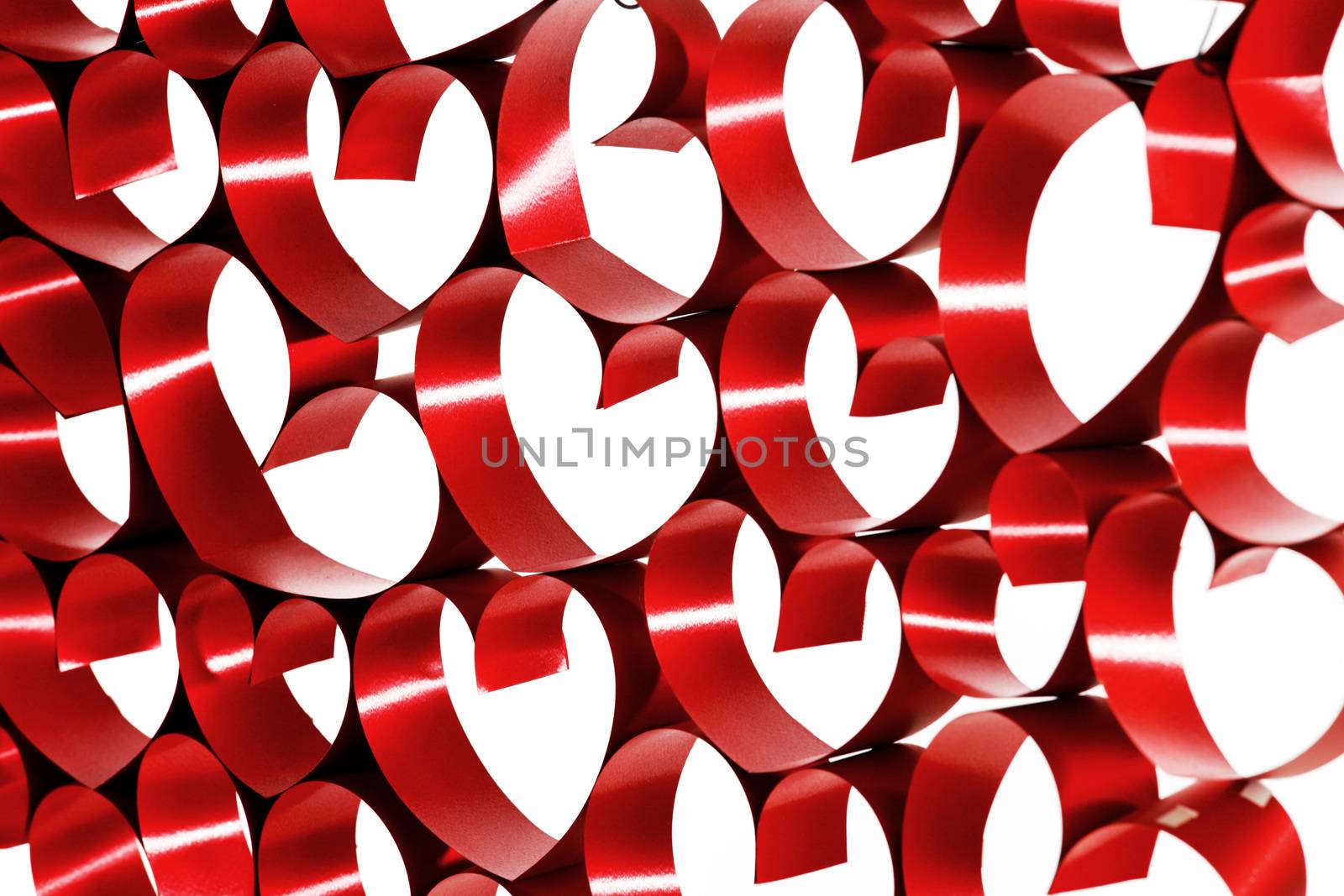 Red ribbons shaped as hearts on white background