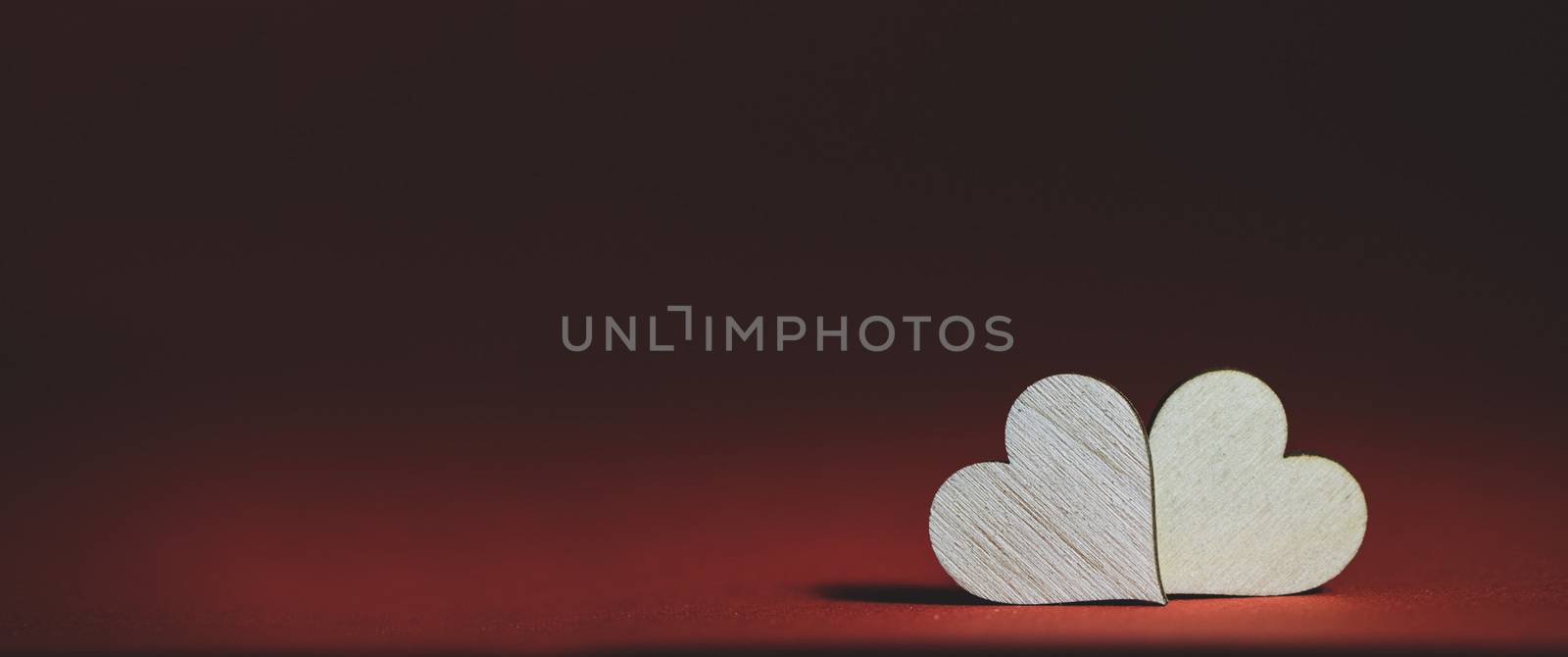 Two handmade wooden carved hearts on brown background couple relationship Valentine day concept