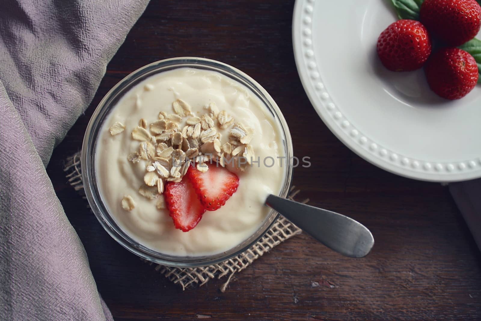 In images Healthy breakfast: yogurt with fruits and strawberry sandwich on white rustic table, top view.