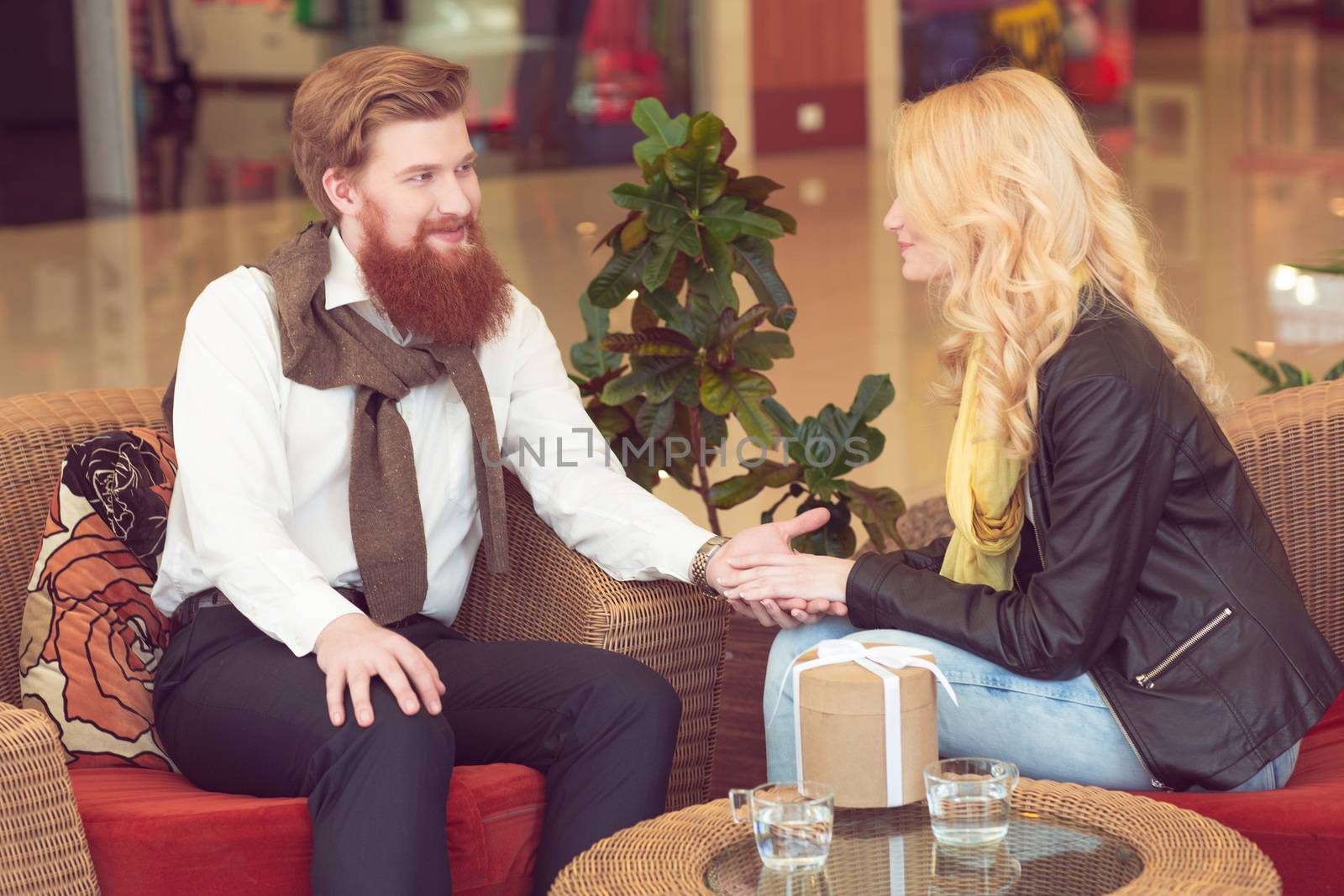 Surprised woman sitting by the table in cafe and getting a gift. Dating , Valentines day concept