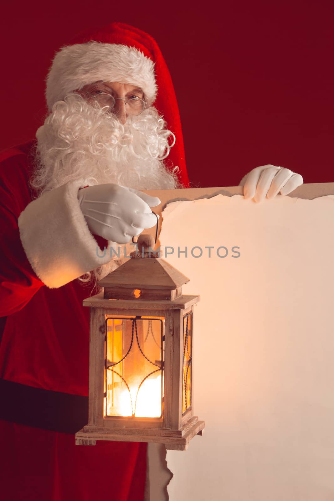 Santa Claus with lantern holding vintage paper billboard with copy space for text