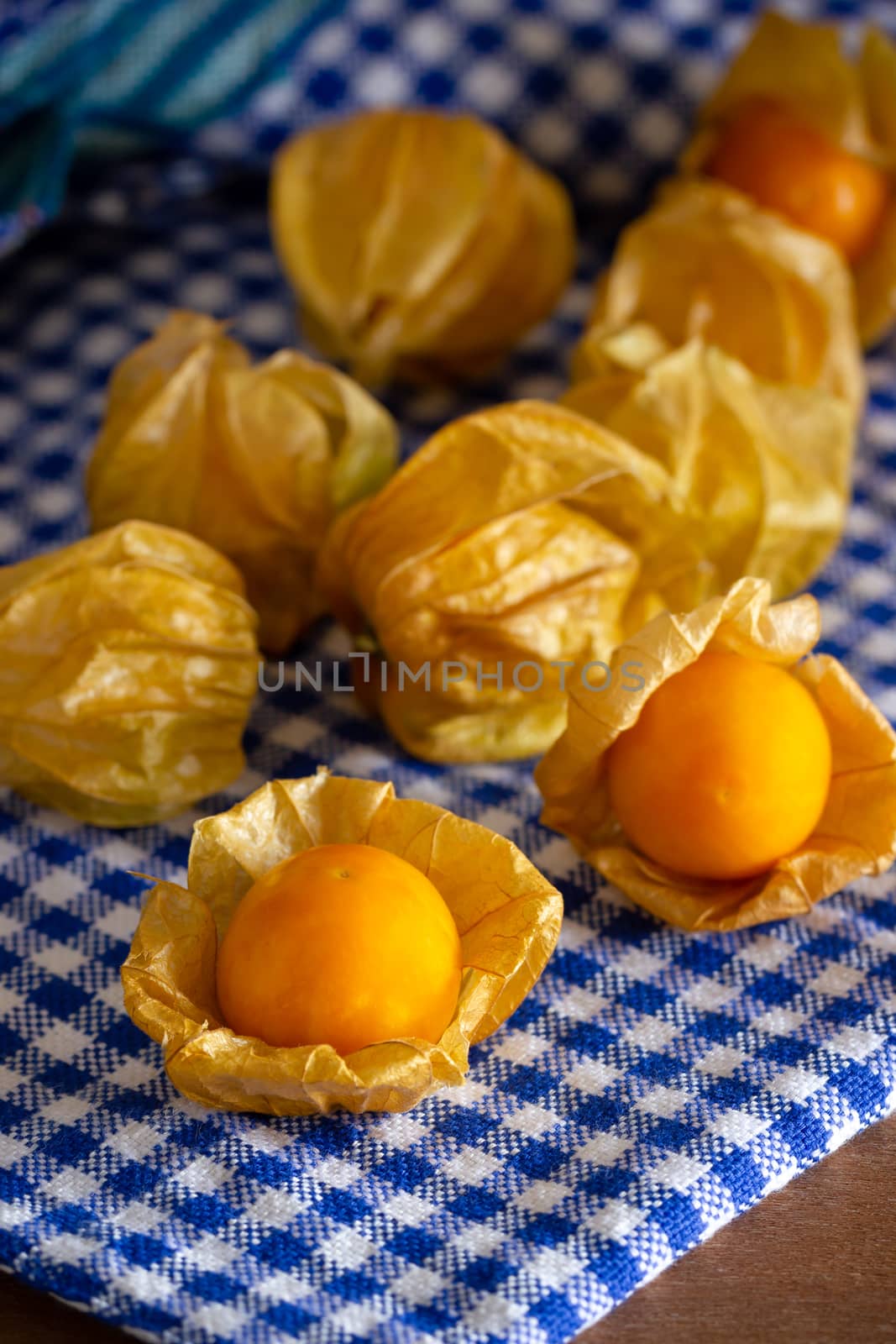 Cape gooseberry on blue tablecloth. Concept of health care or herb.