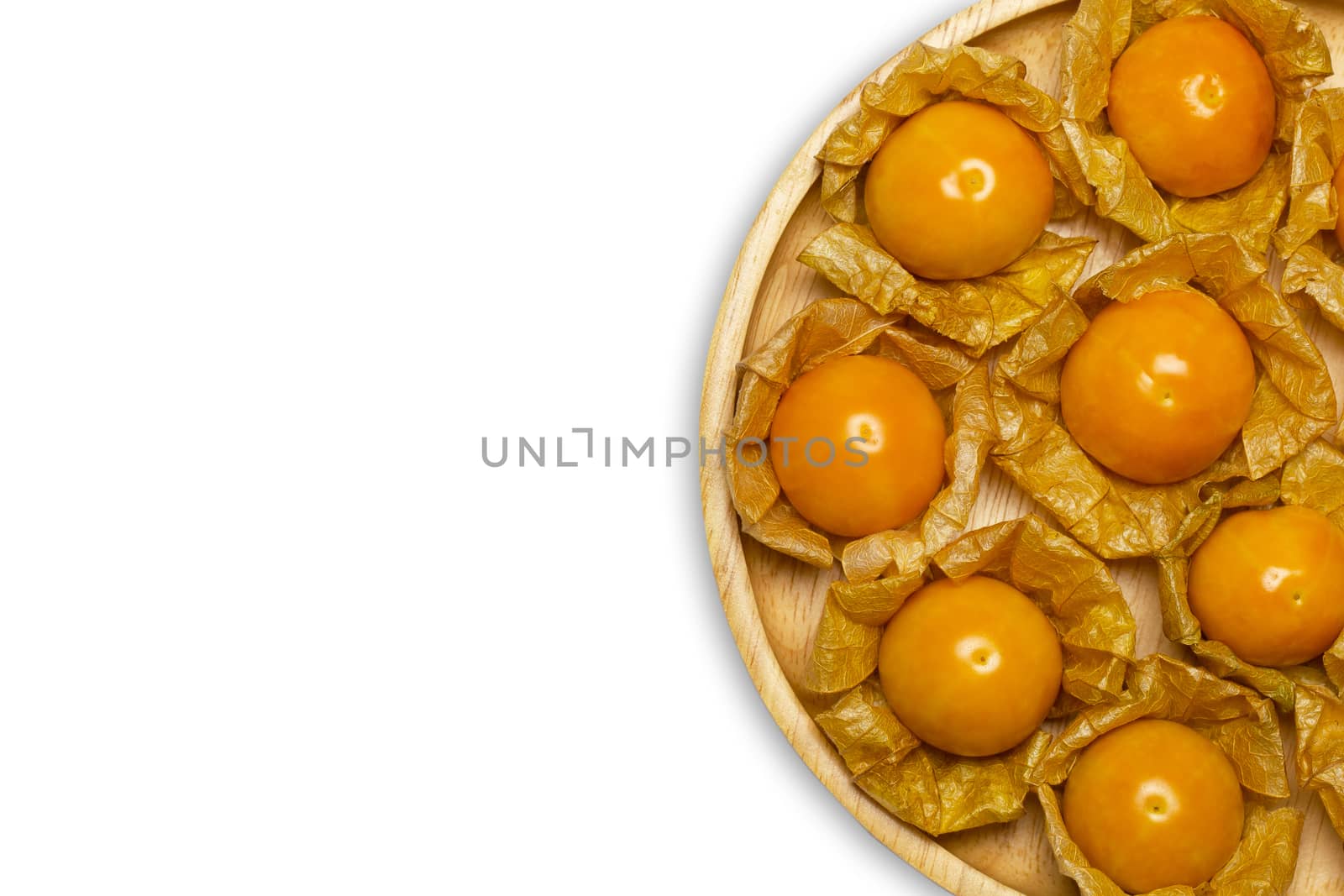 Cape gooseberry on wooden dish in white background. Concept of health care or herb. Top view and copy space for text.