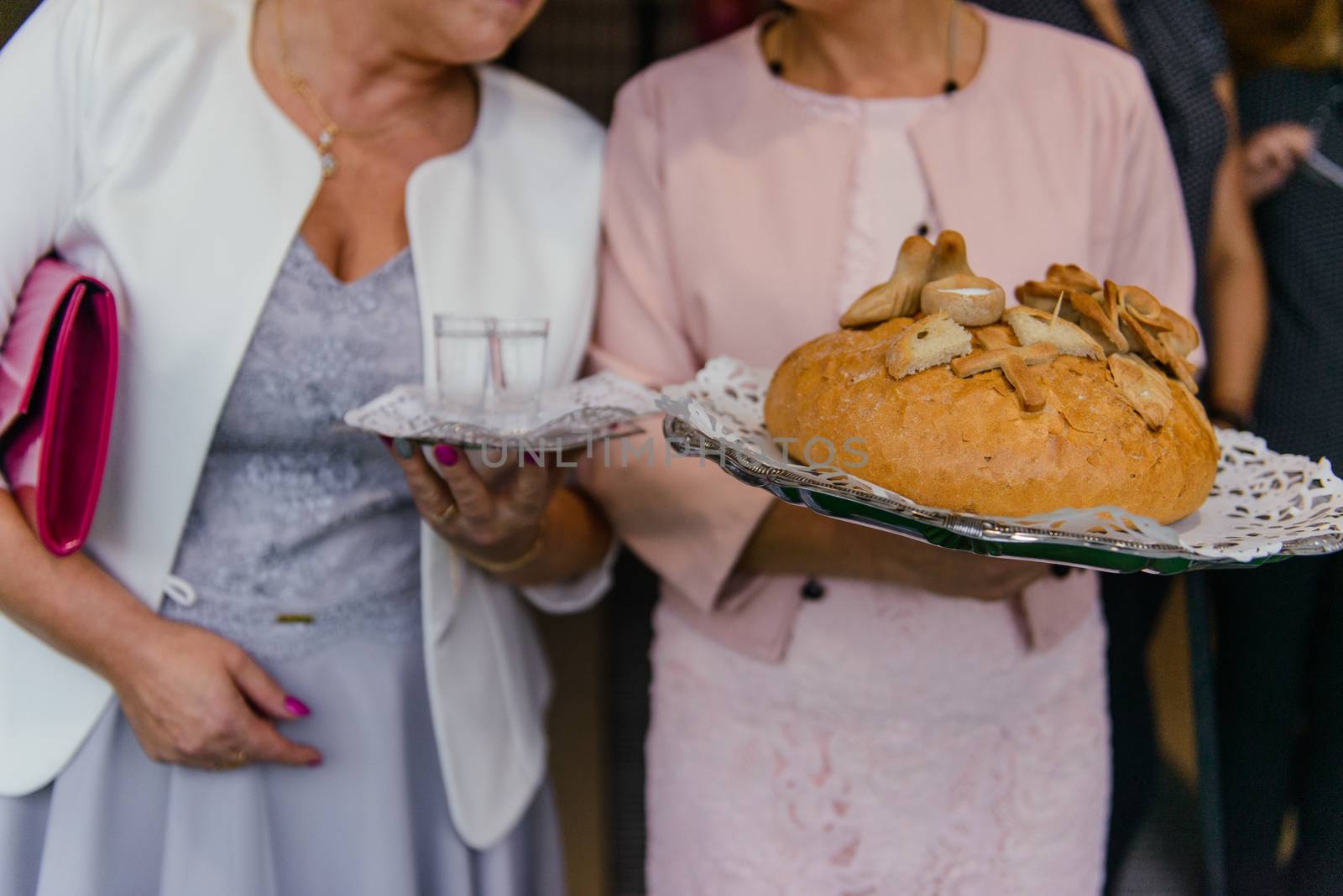Traditional polish greeting the bride and groom by the parents with bread and salt. Vodka also in glasses.