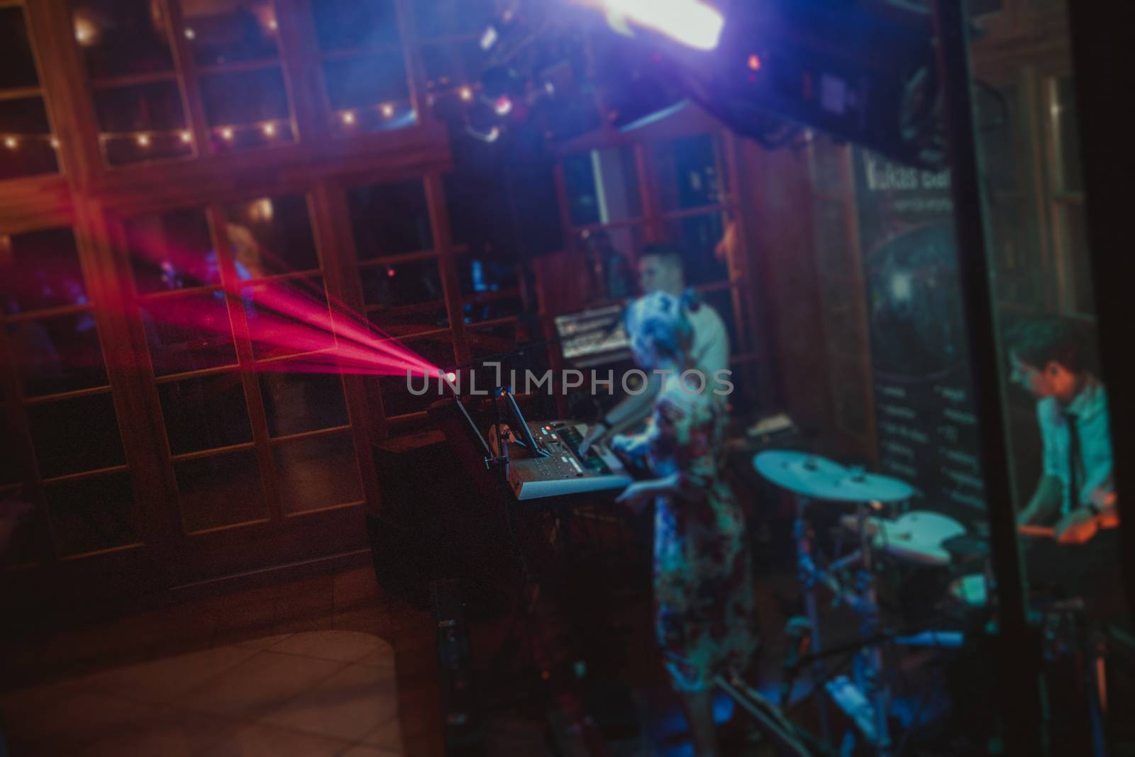 DJ plays music at wedding party. Colorful light rays.