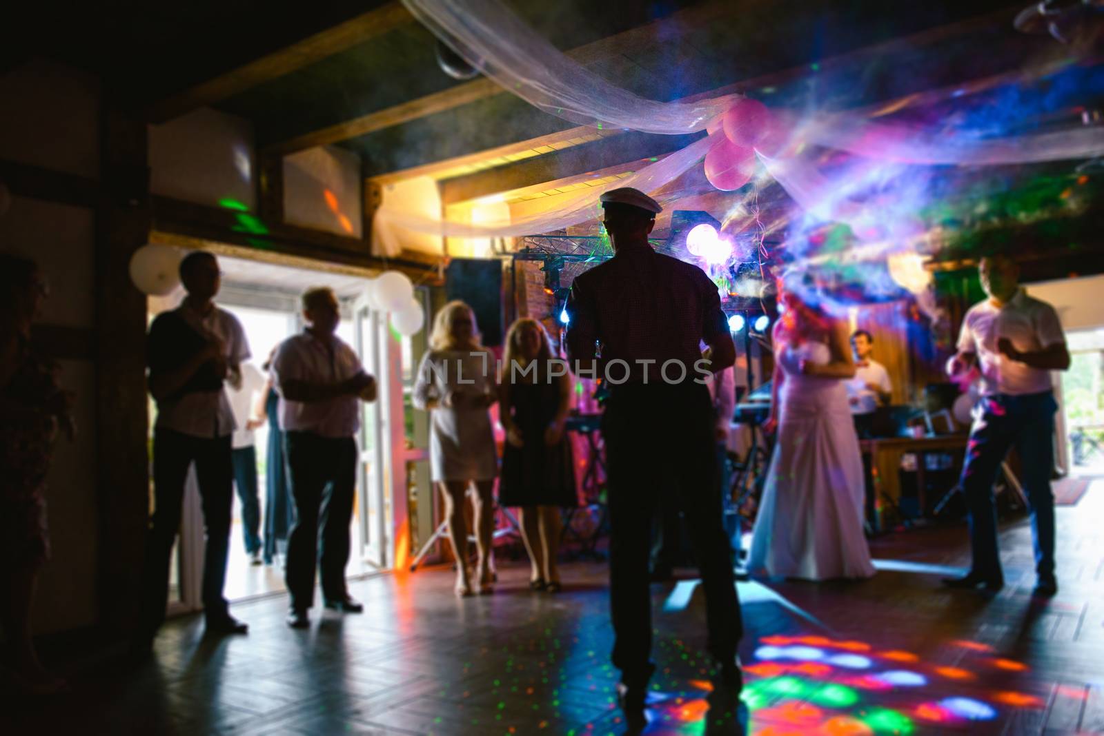 Bride and groom dancing the first dance at their wedding day. Guest on the dancefloor