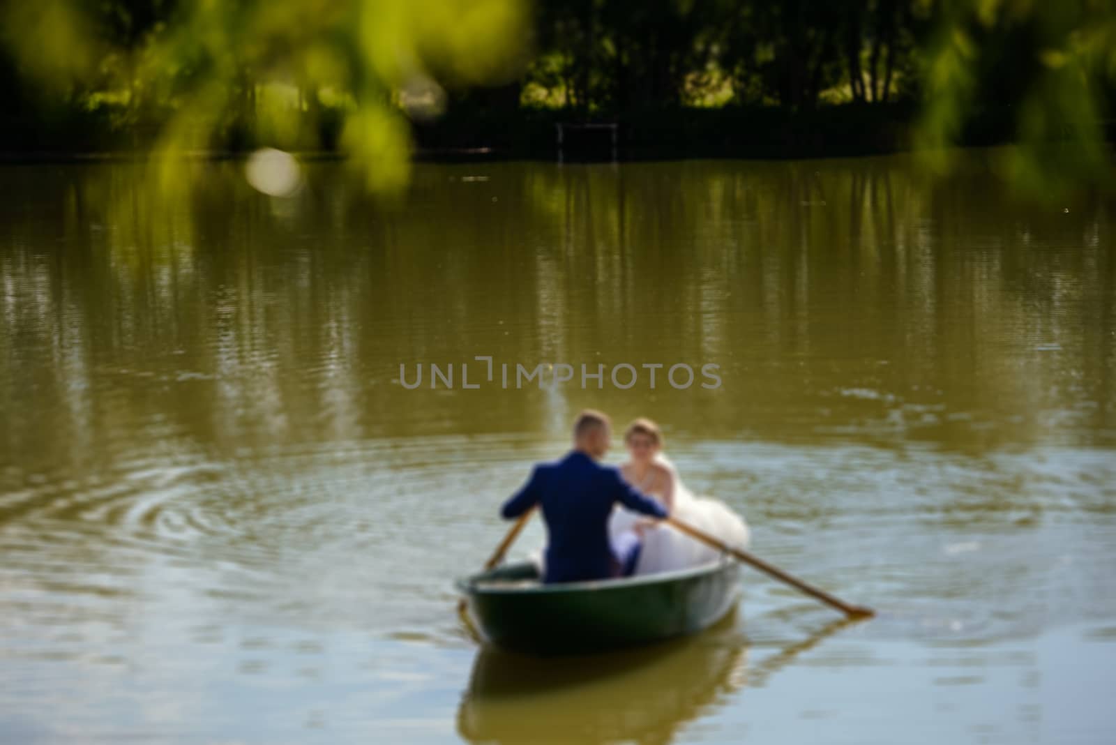 Bride and groom at a photo session in the nature. Newlyweds in the boat on the lake