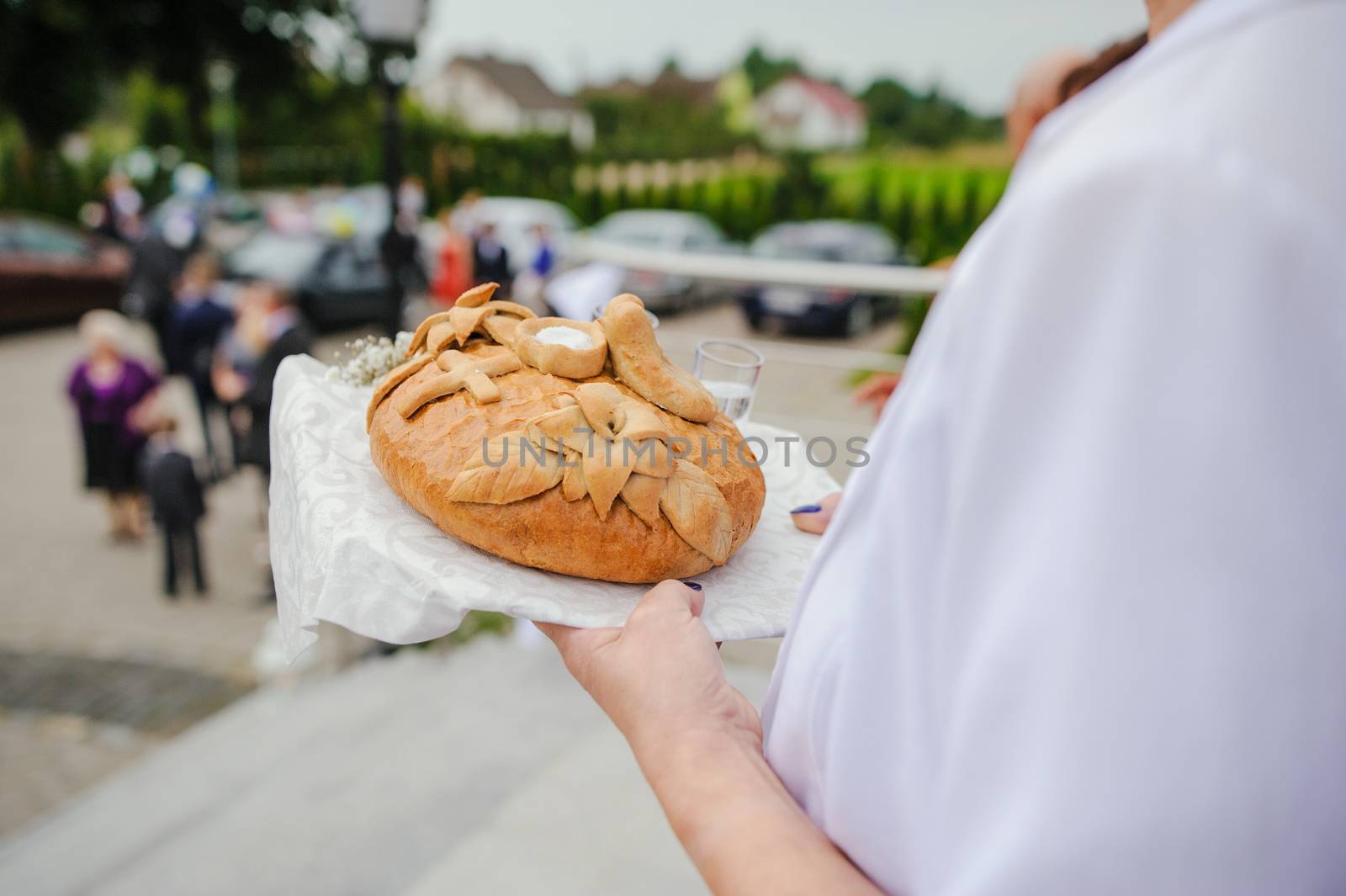 Traditional polish greeting the bride and groom by the parents with bread and salt. Vodka also in glasses.