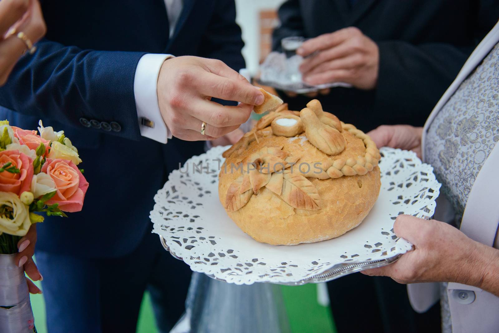 Traditional polish greeting the bride and groom by the parents with bread and salt. Vodka also in glasses.