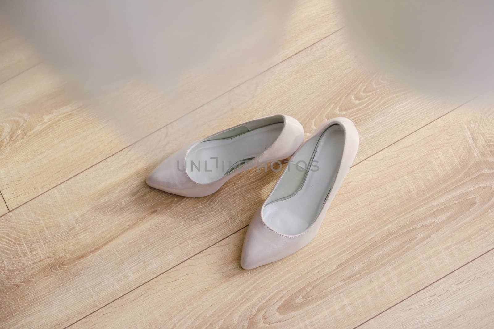 The bride shows white wedding shoes. Wedding detail. Close up