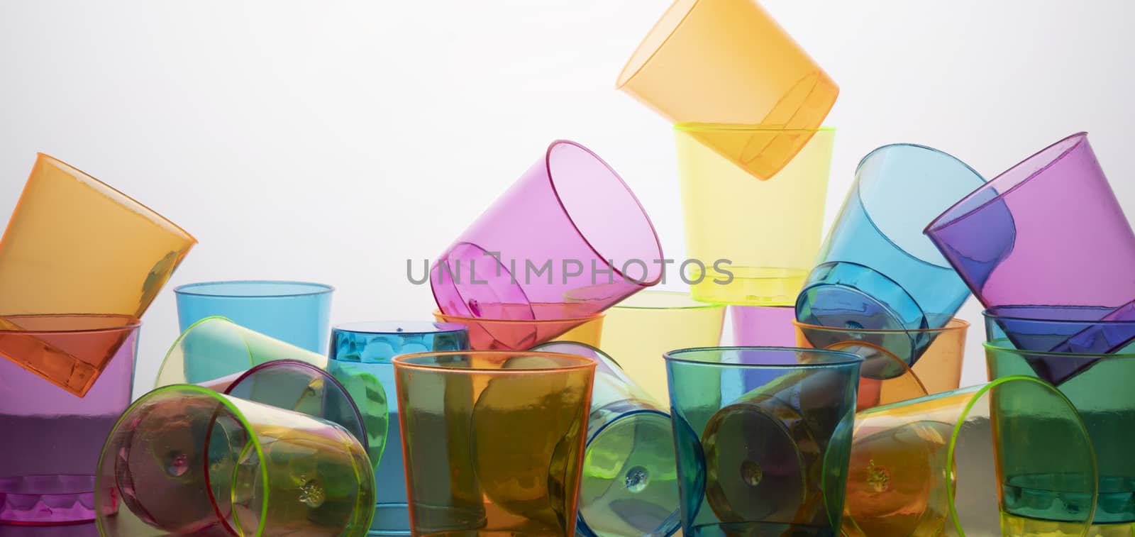 some empty colored glasses scattered on a surface