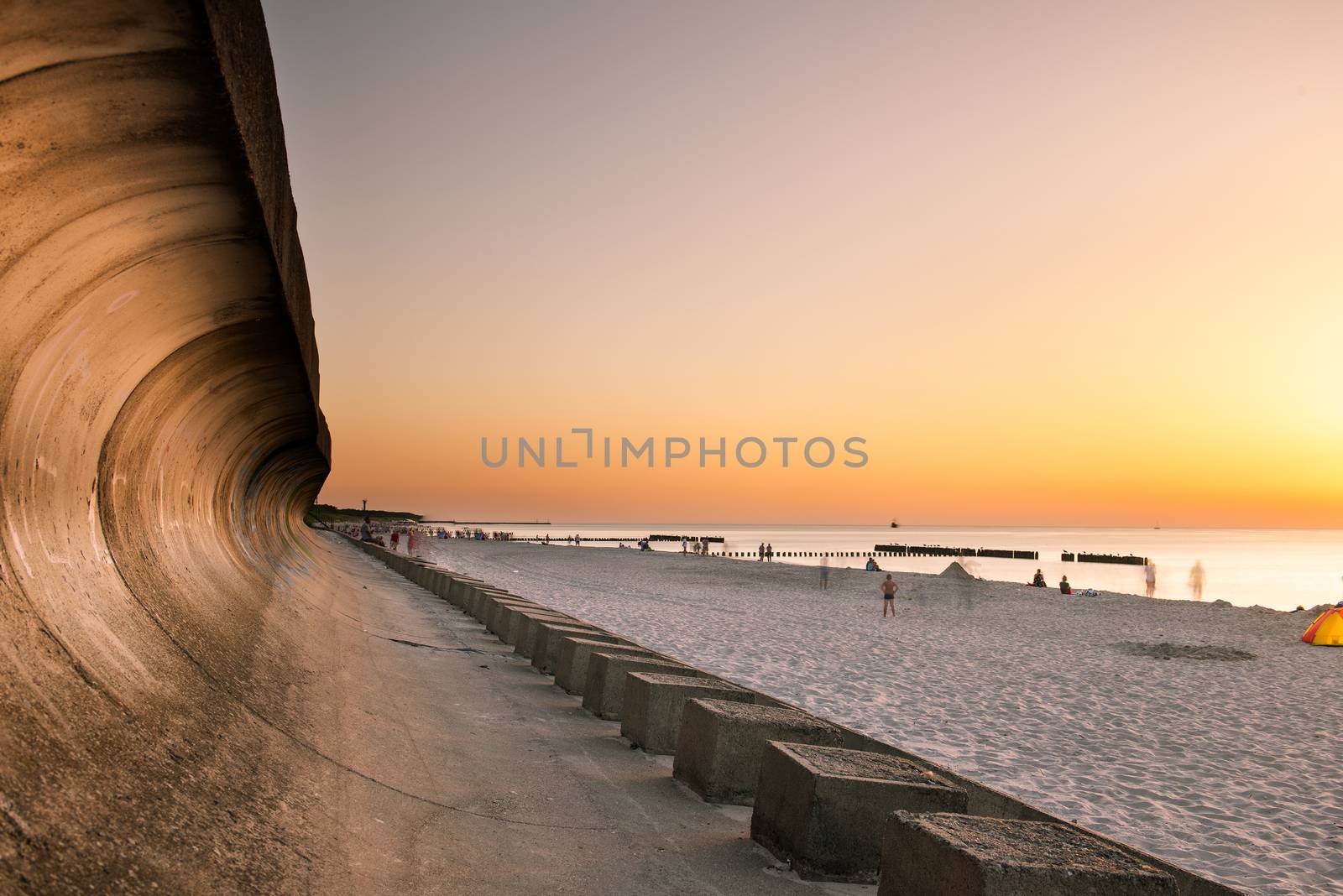 A photograph of wooden breakwater and seagulls at sunset on the Baltic Sea