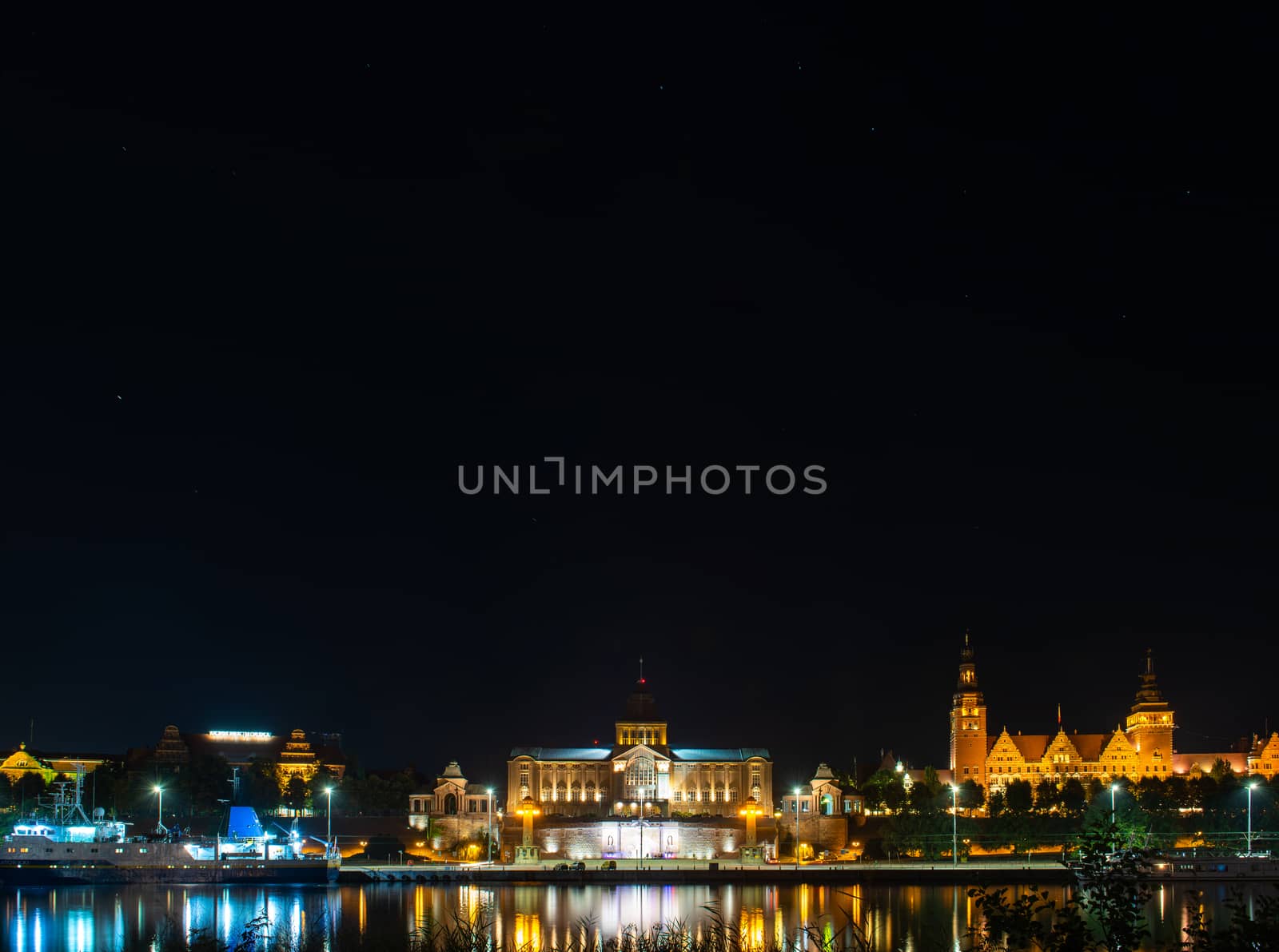 Szczecin. Night view from across the river to the illuminated historic center. Odra river. Chrobry embankments in Szczecin