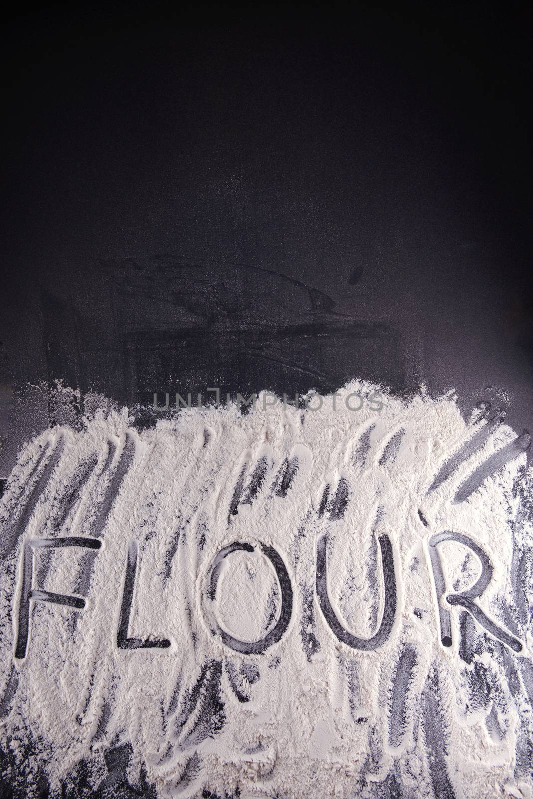 Word food written with flour on black background.