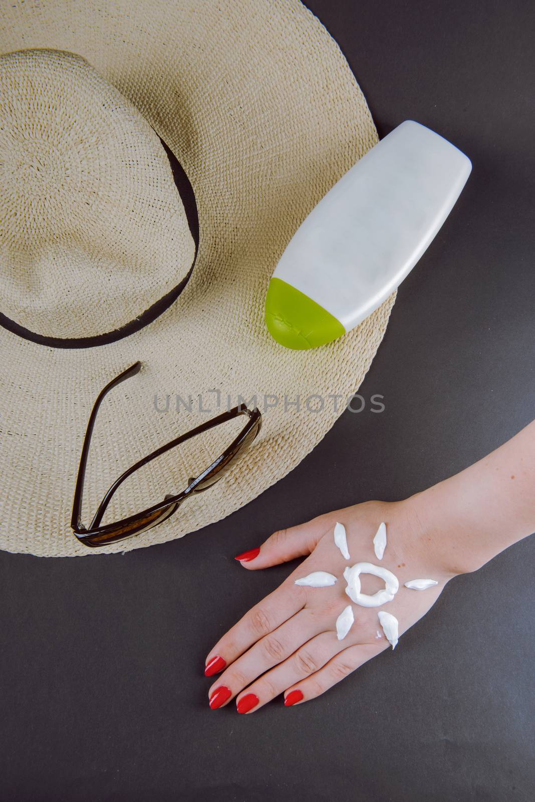 woman applying sunscreen cream on Hand. Red nails.