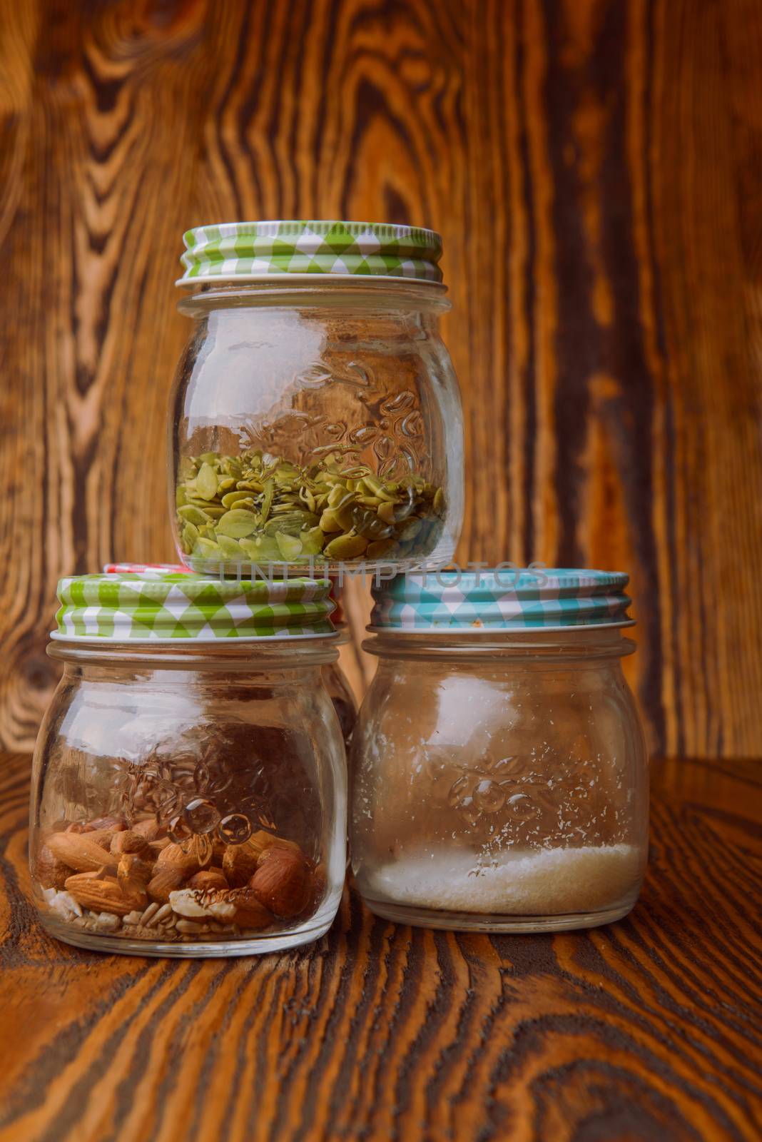 Almonds in a jar on the blue wooden table.