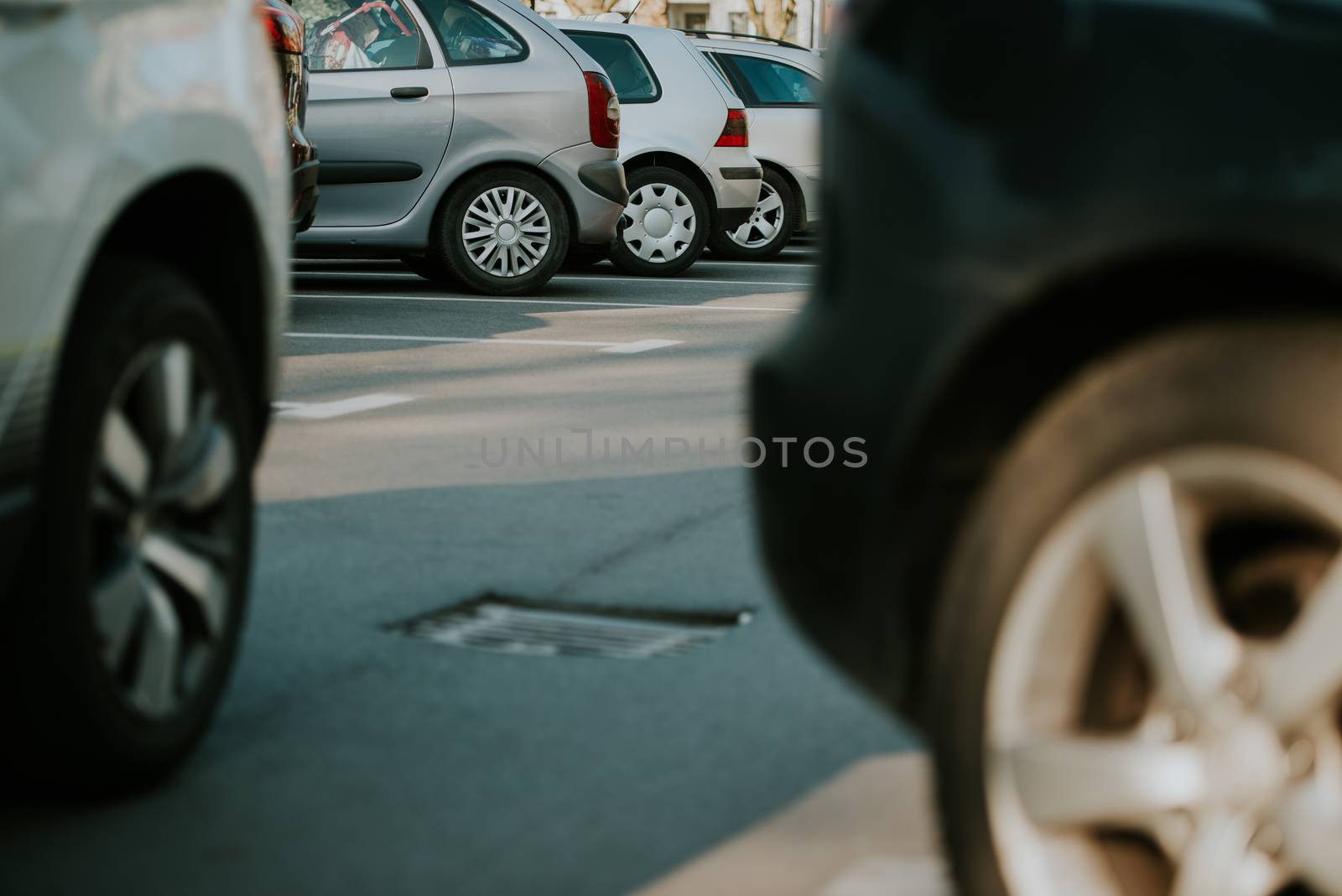 View of tightly packed cars in parking lot.