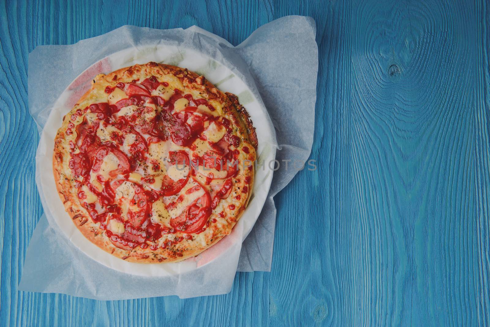 Homemade pepperoni pizza on the table. Tomato, cheese and ham main ingredients.
