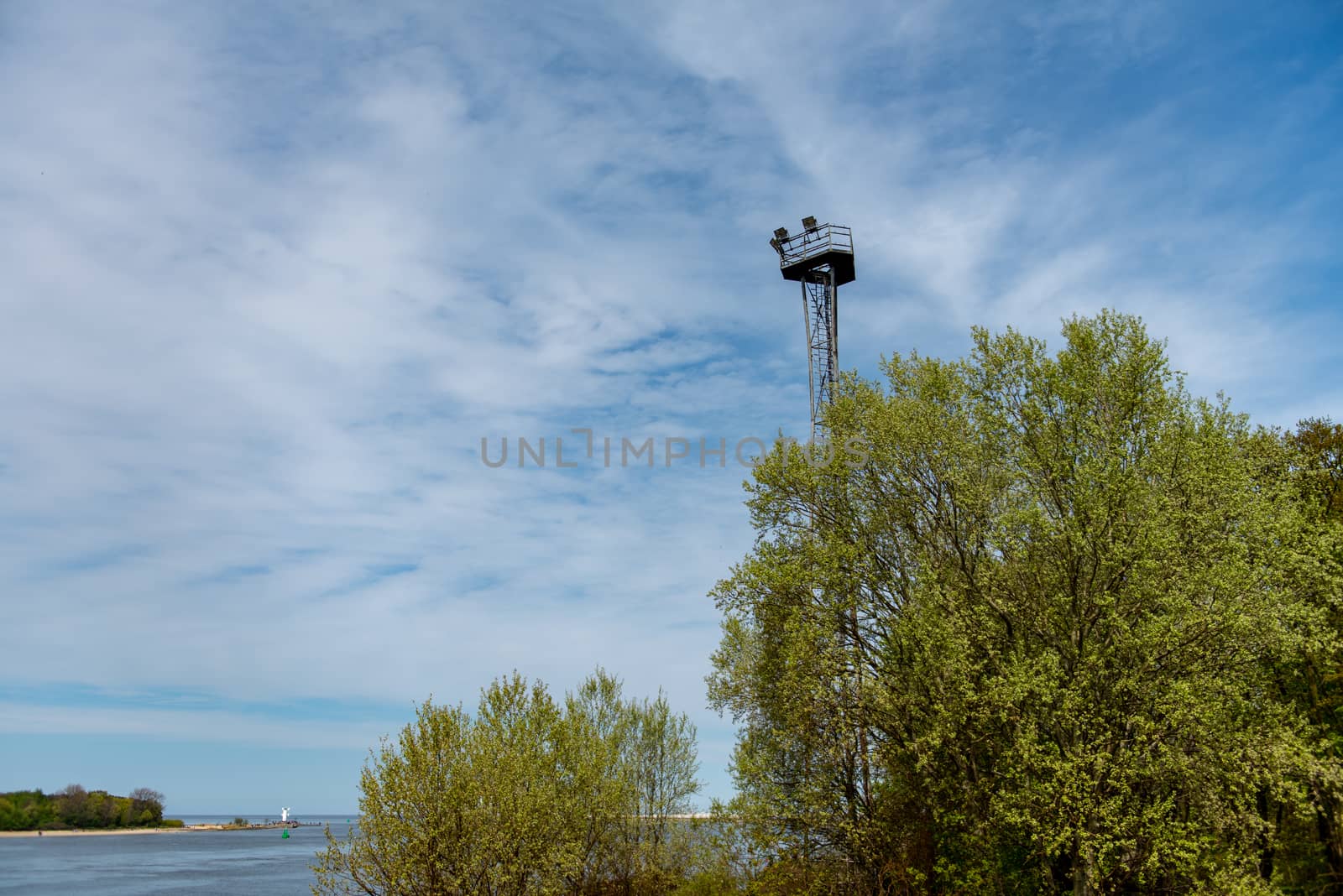 Observation tower with copy space. Blue sky and green trees