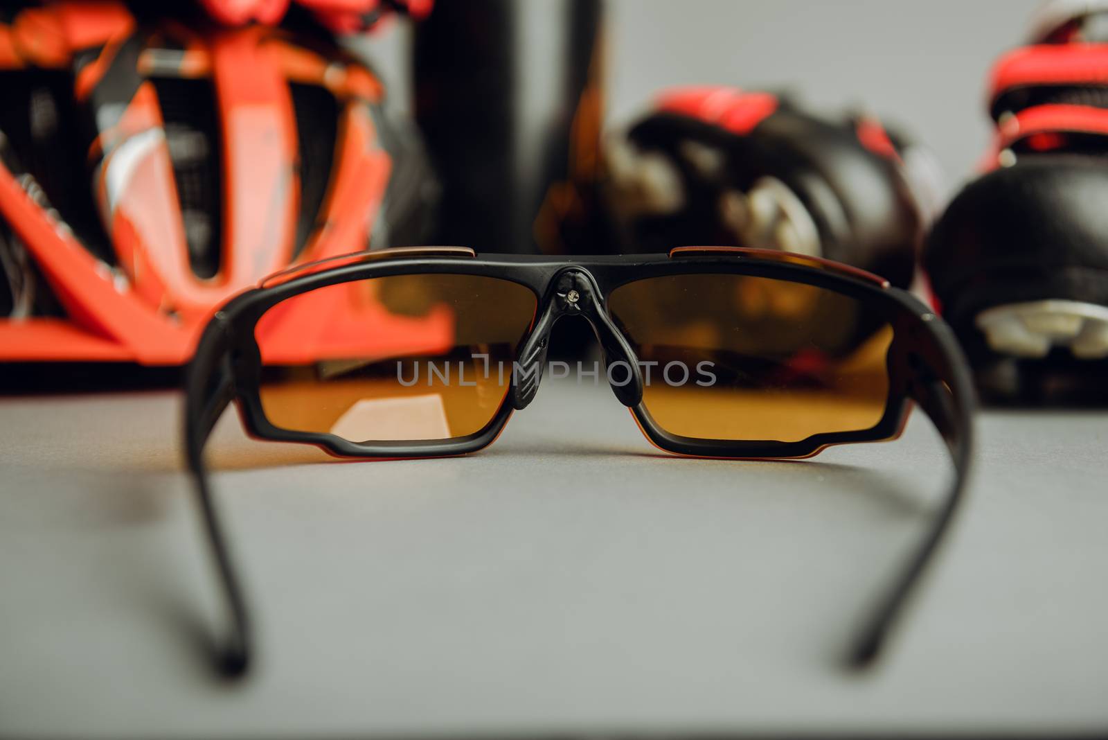 Helmet, gloves, shoes and water bottle - bicycle accessories. Orange color
